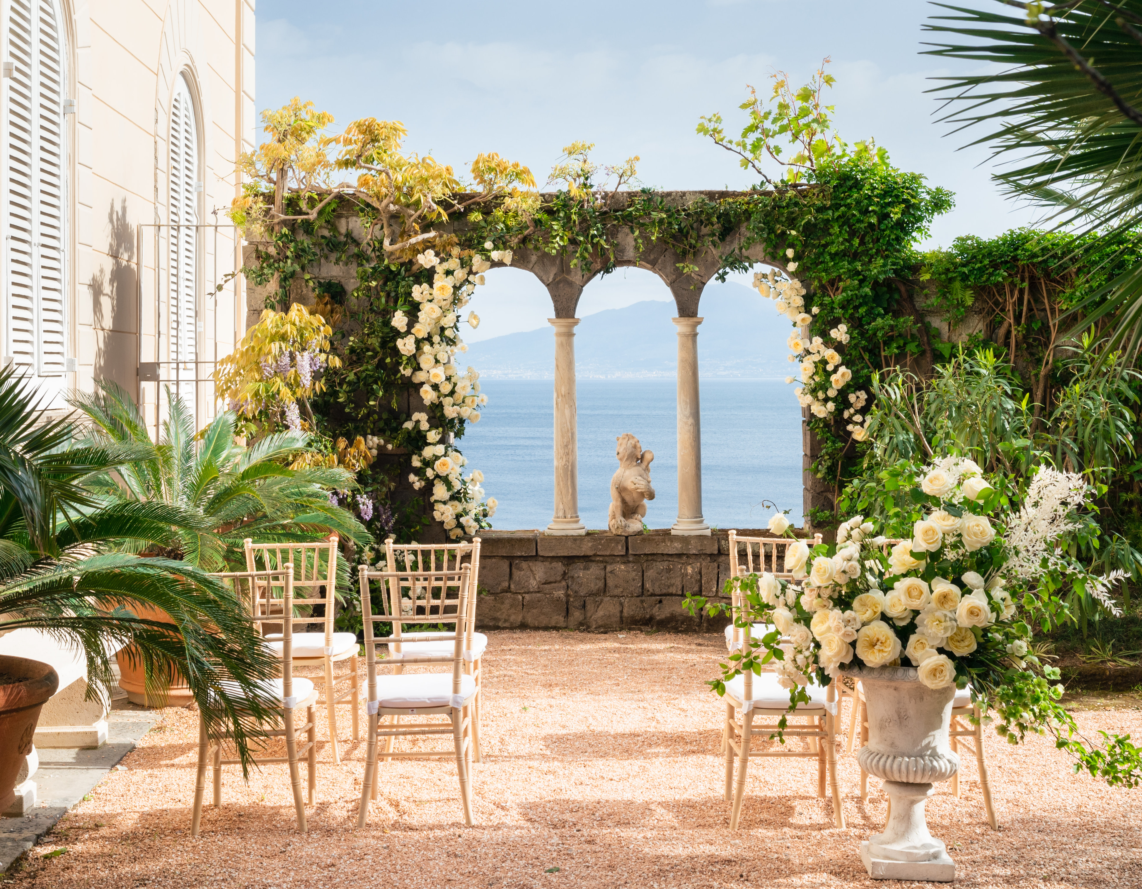 An intimate wedding ceremony is set up outside with a view of the ocean in Italy.