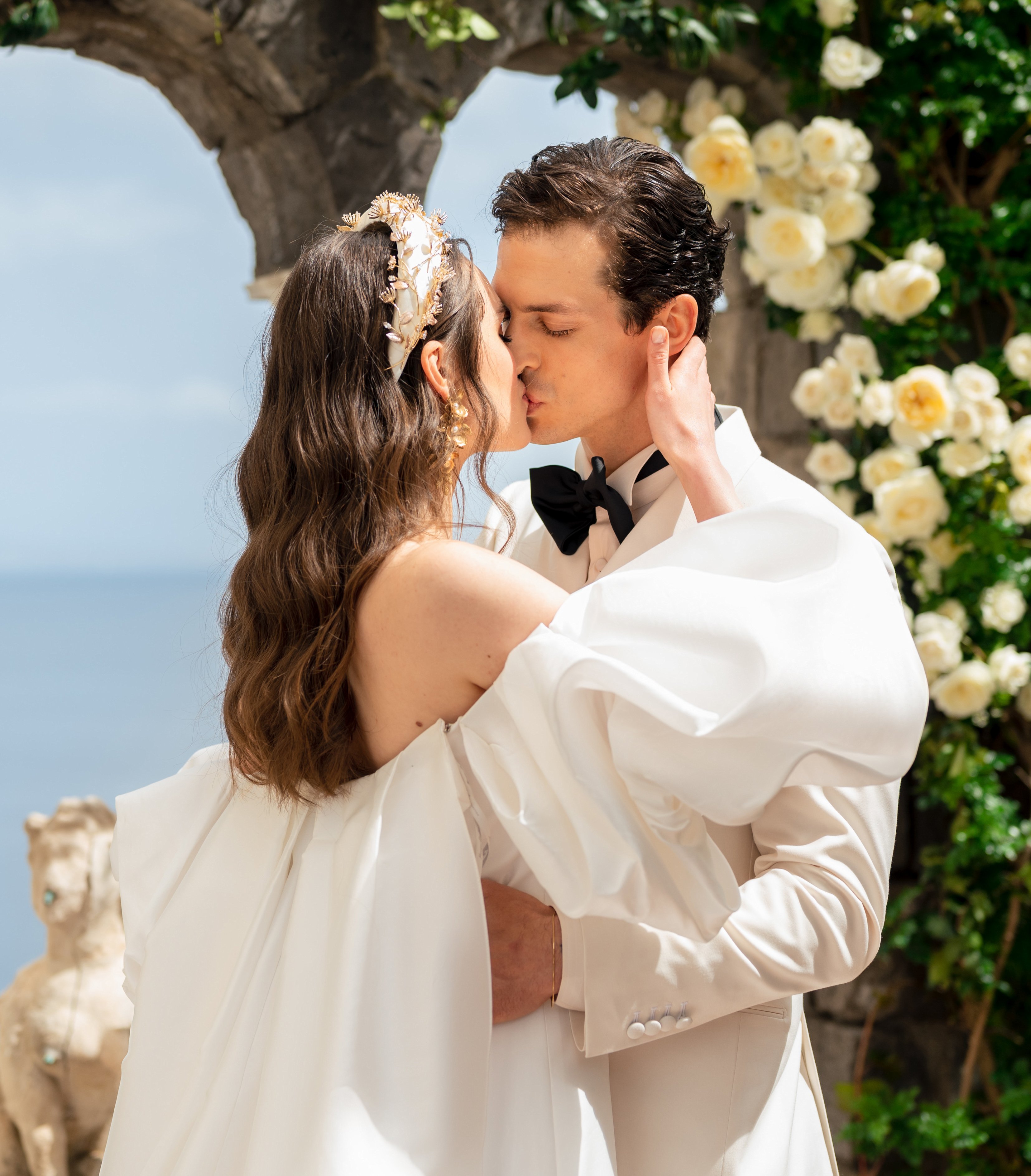 A bride and groom kiss at the altar with the ocean behind them in Amalfi Coast, Italy.