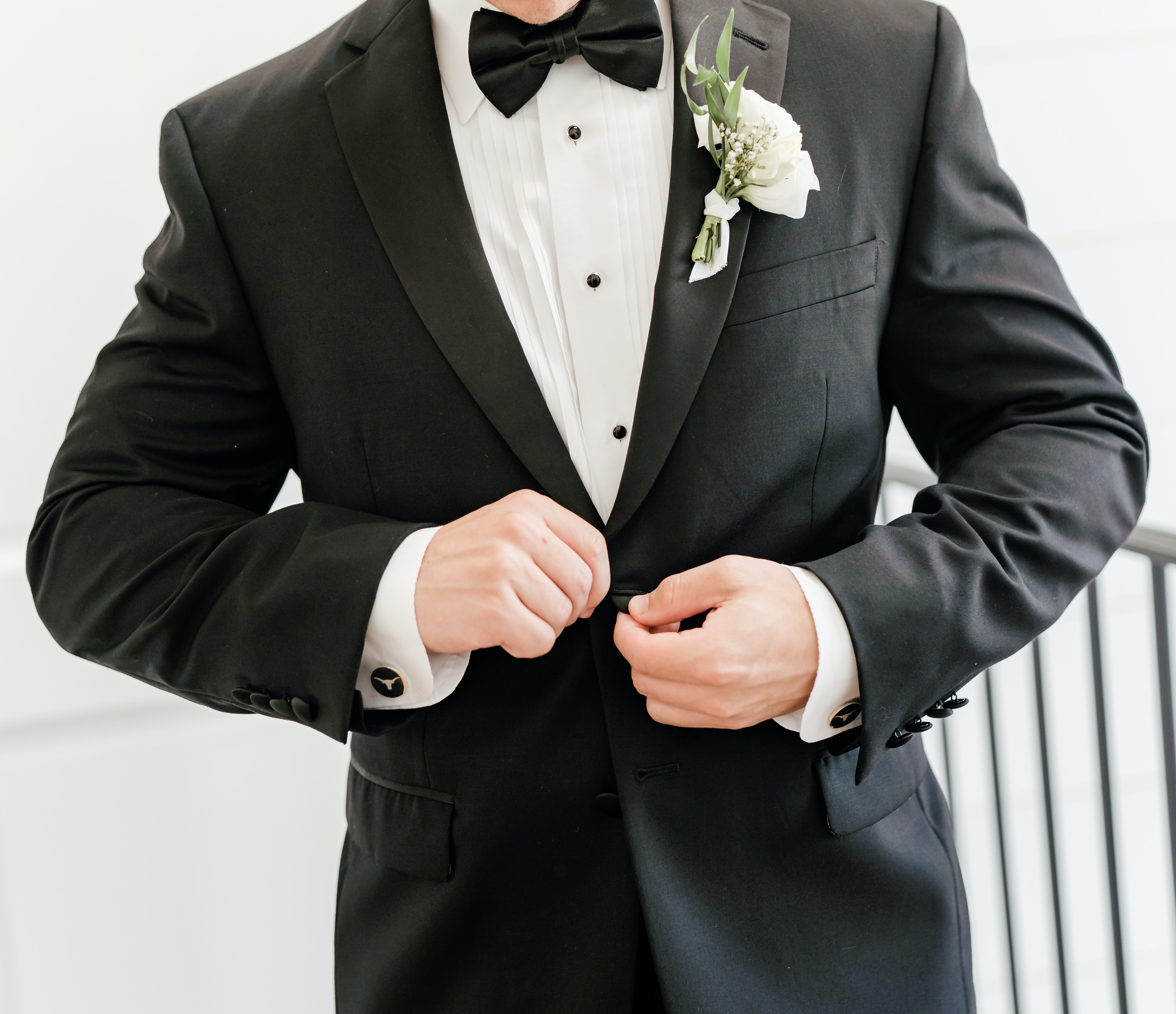 A groom puts his suit jacket on before his wedding in Montgomery, TX.