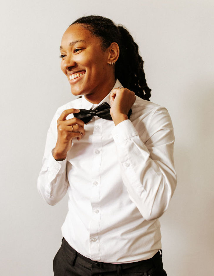 A LGBT bride is fixing her bowtie for a wedding styled shoot in Houston, TX.