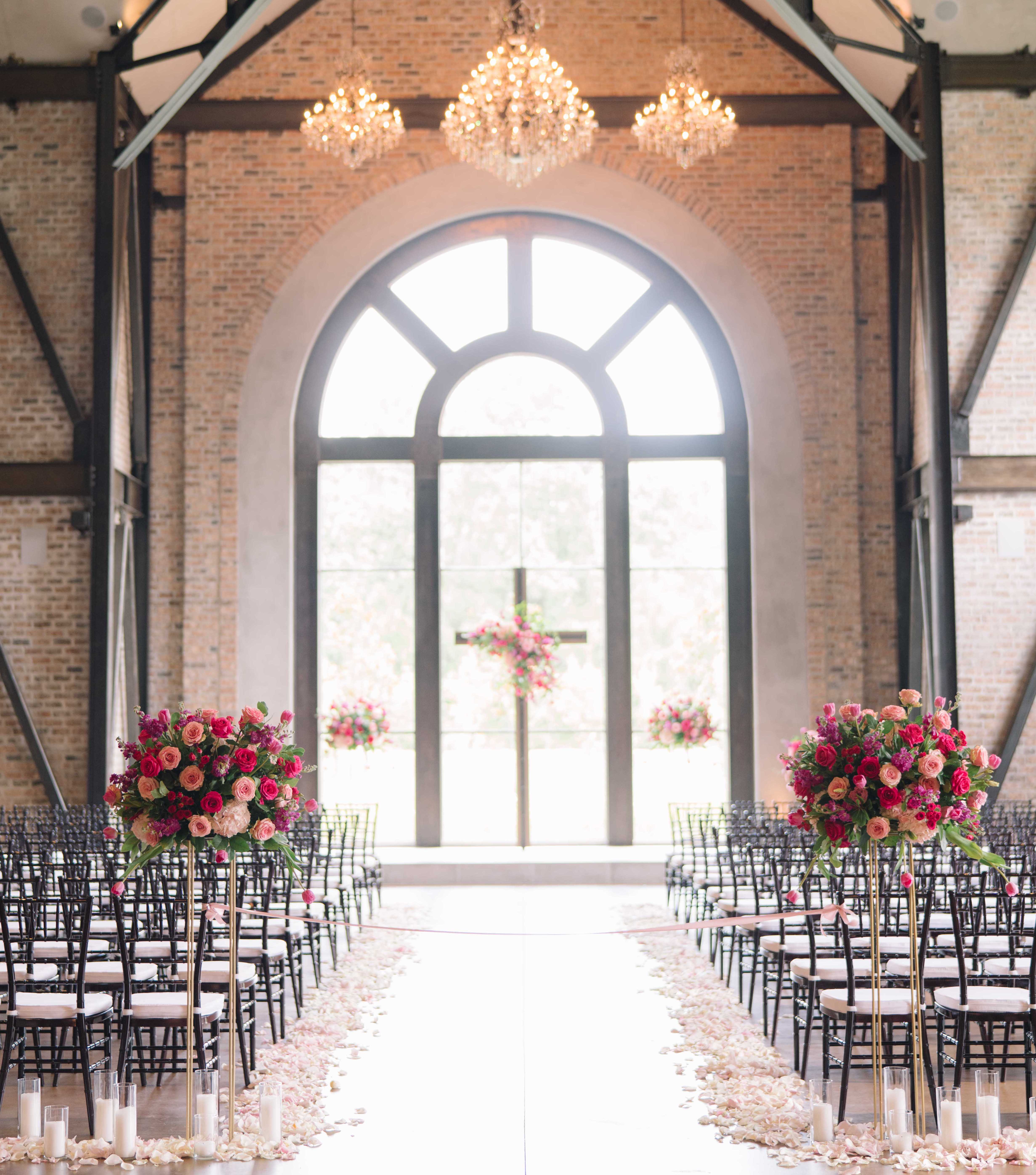 A wedding ceremony is set up with bright pink decor in Conroe, TX.
