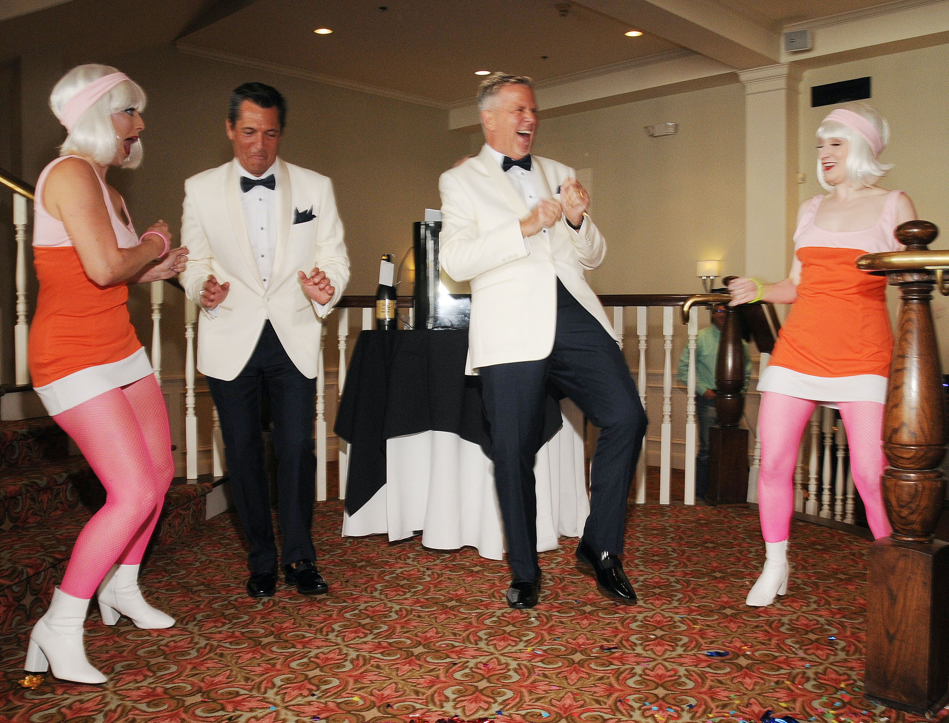 A groom and groom are surprised by Go-Go dancers at their wedding in Galveston, TX at The Tremont House Hotel.