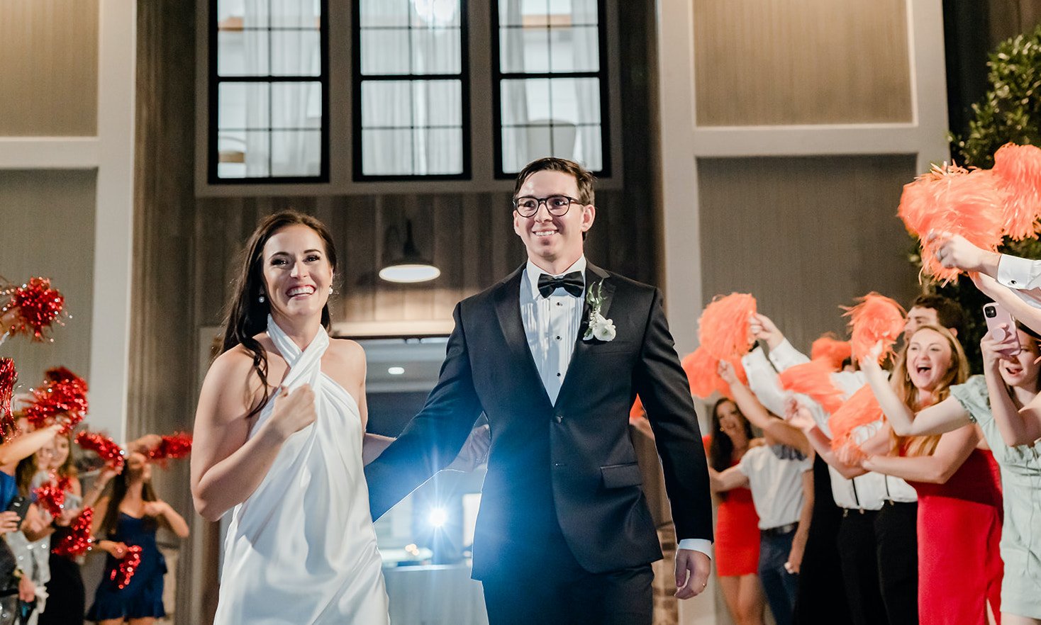 A bride changed into a reception dress and is running with her groom through a path of their friends and family after their wedding in Montgomery, TX.