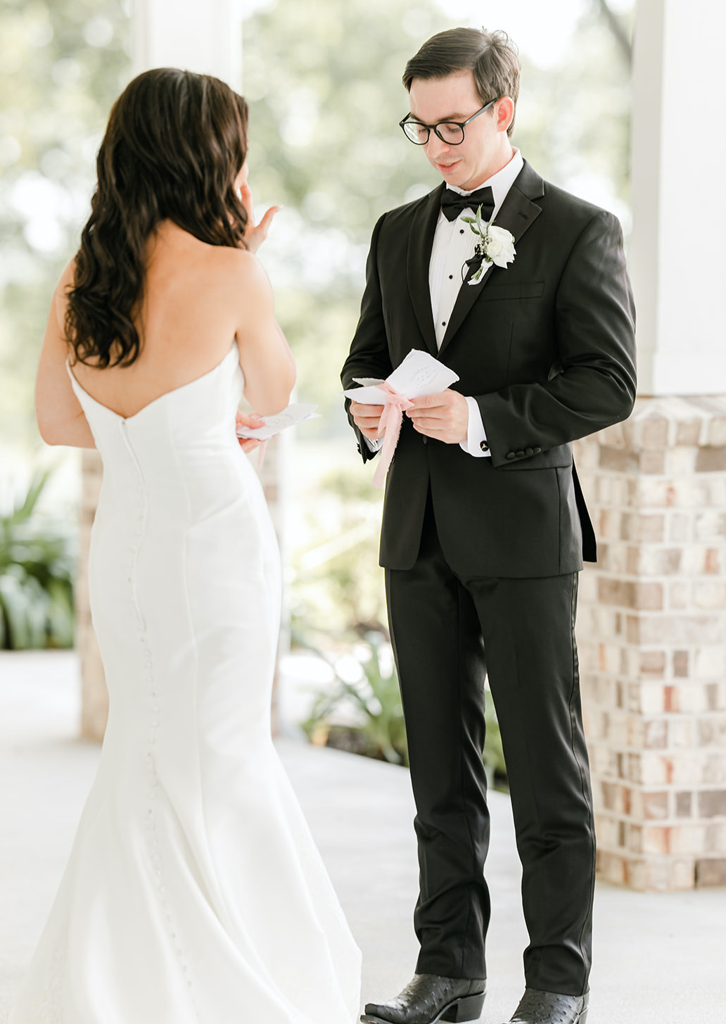 A bride and groom read their vows to each other outside at a Texas venue.
