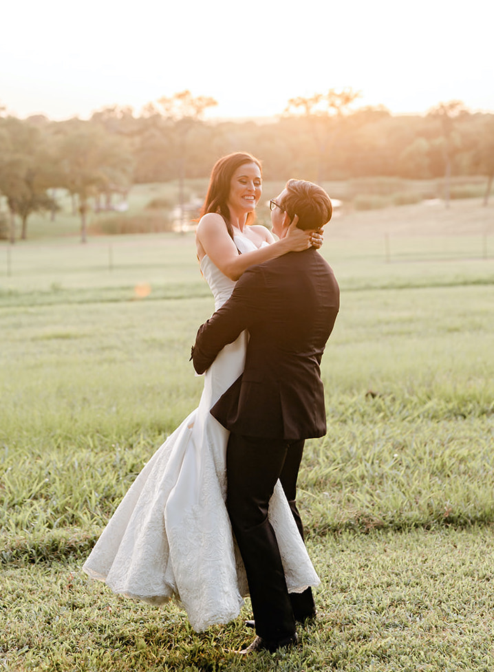 A groom picks up his bride in a field in Texas.