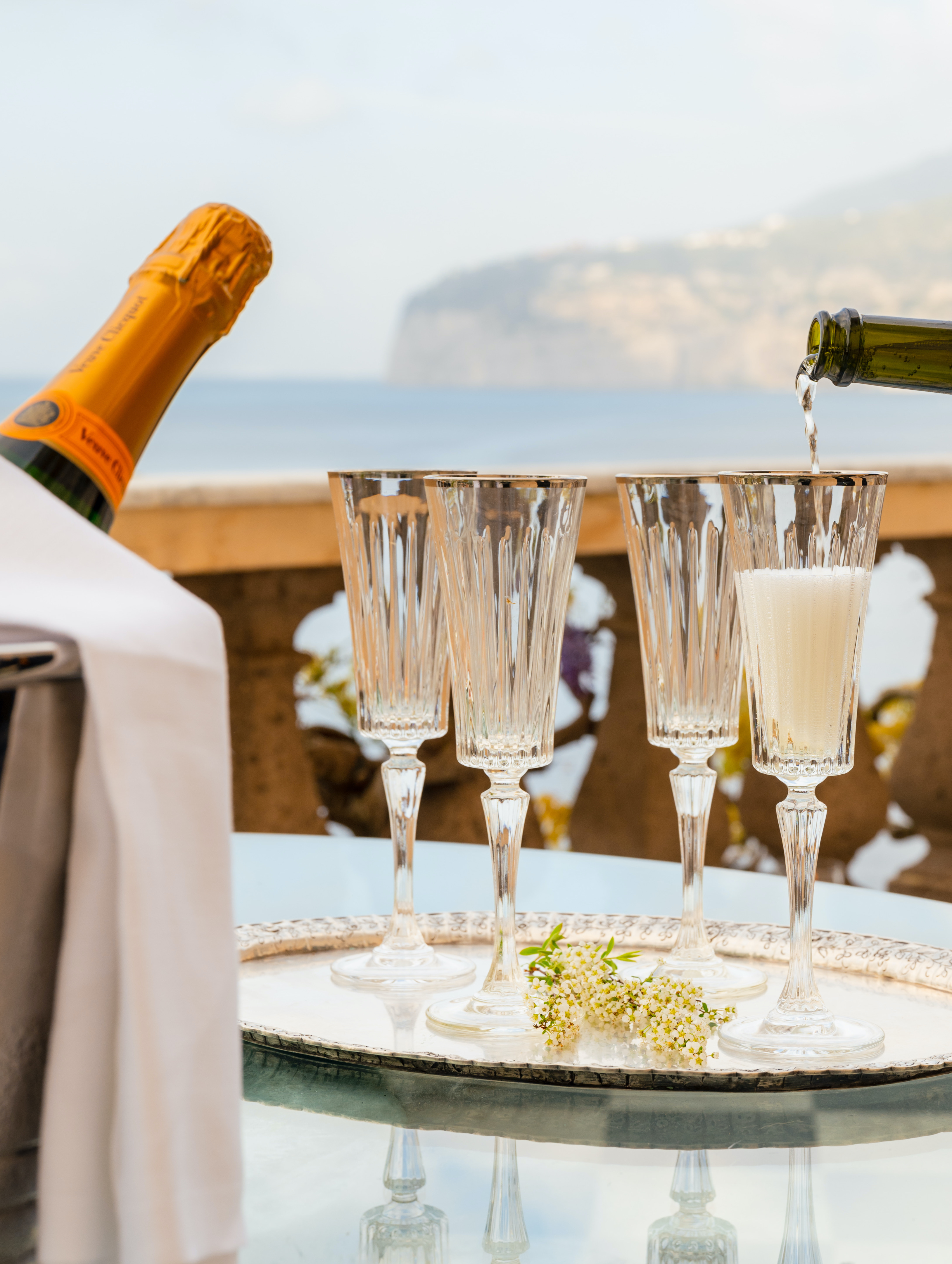 Veuve Cliquot champagne is being poured in crystal glasses at a wedding on the Amalfi Coast.