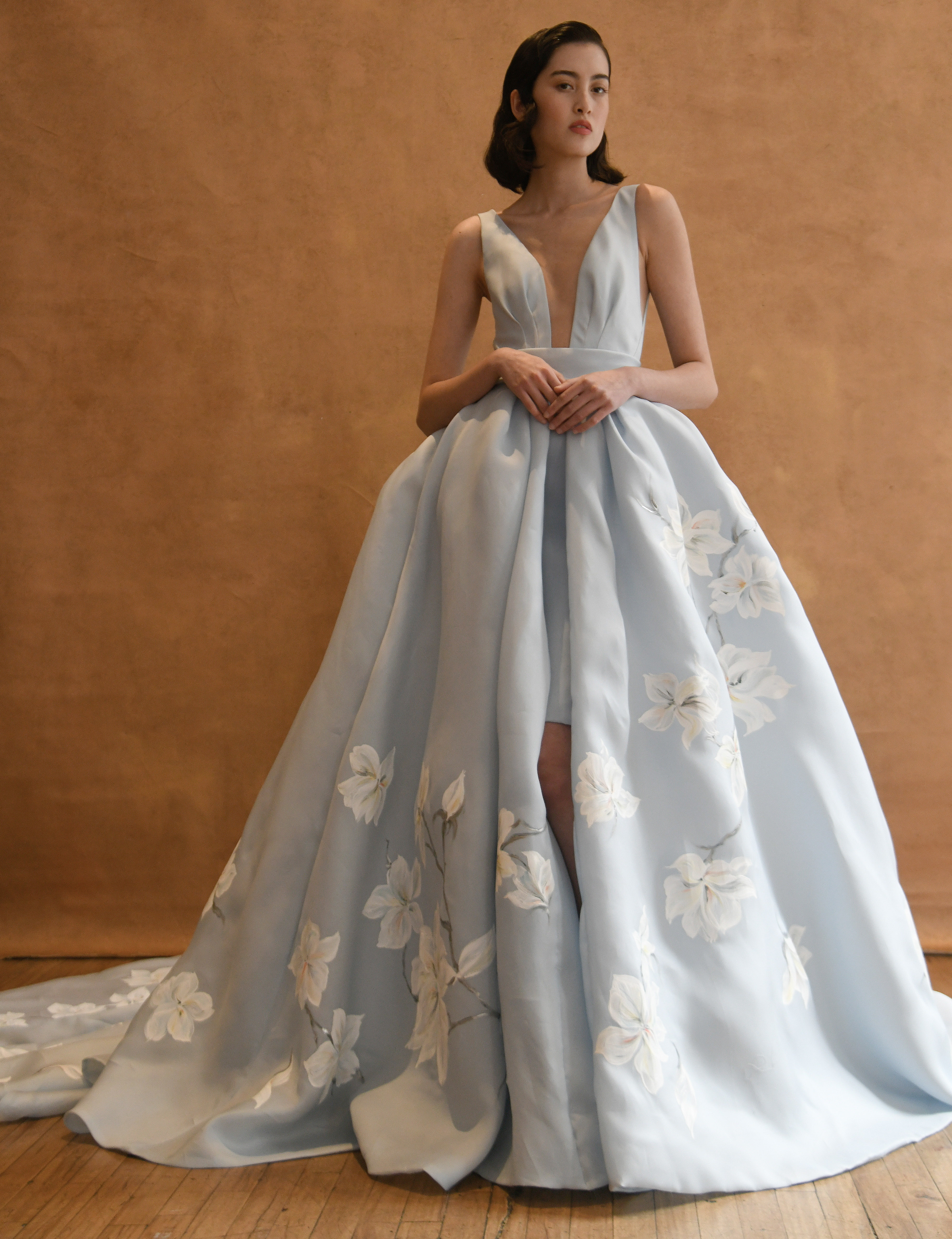 designed by Ines Di Santo. A baby blue wedding gown with white flowers trailing down the skirt.