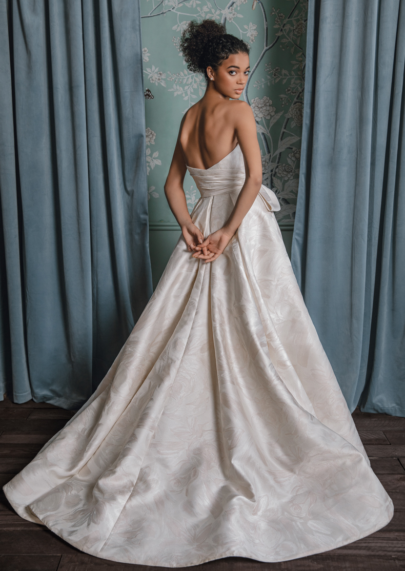 A strapless blush wedding gown with floral designs on it designed by Anne Barge for wedding gowns for the spring and summer