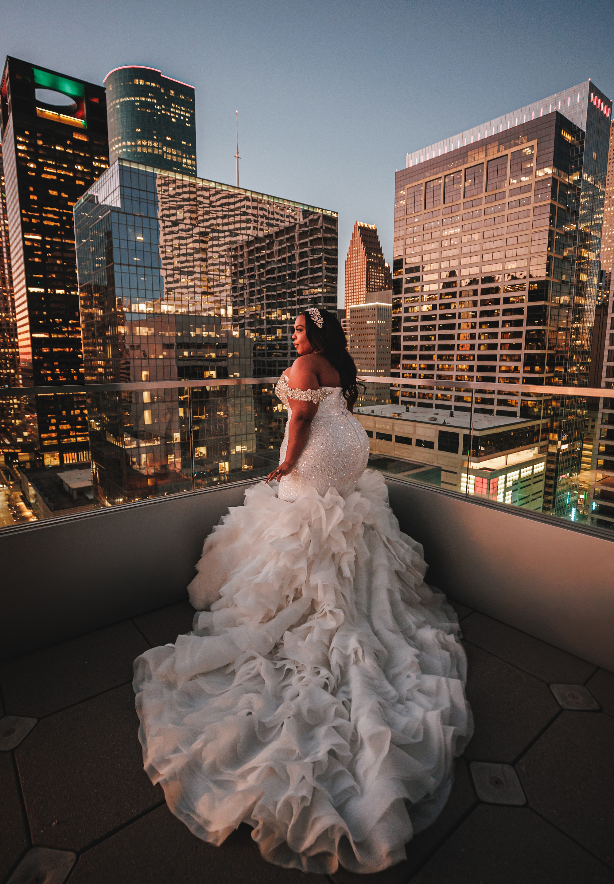 Bride, Ashley Turner, wears her bridal gown with a long ruffled skirt during her Houston skyline bridal shoot.