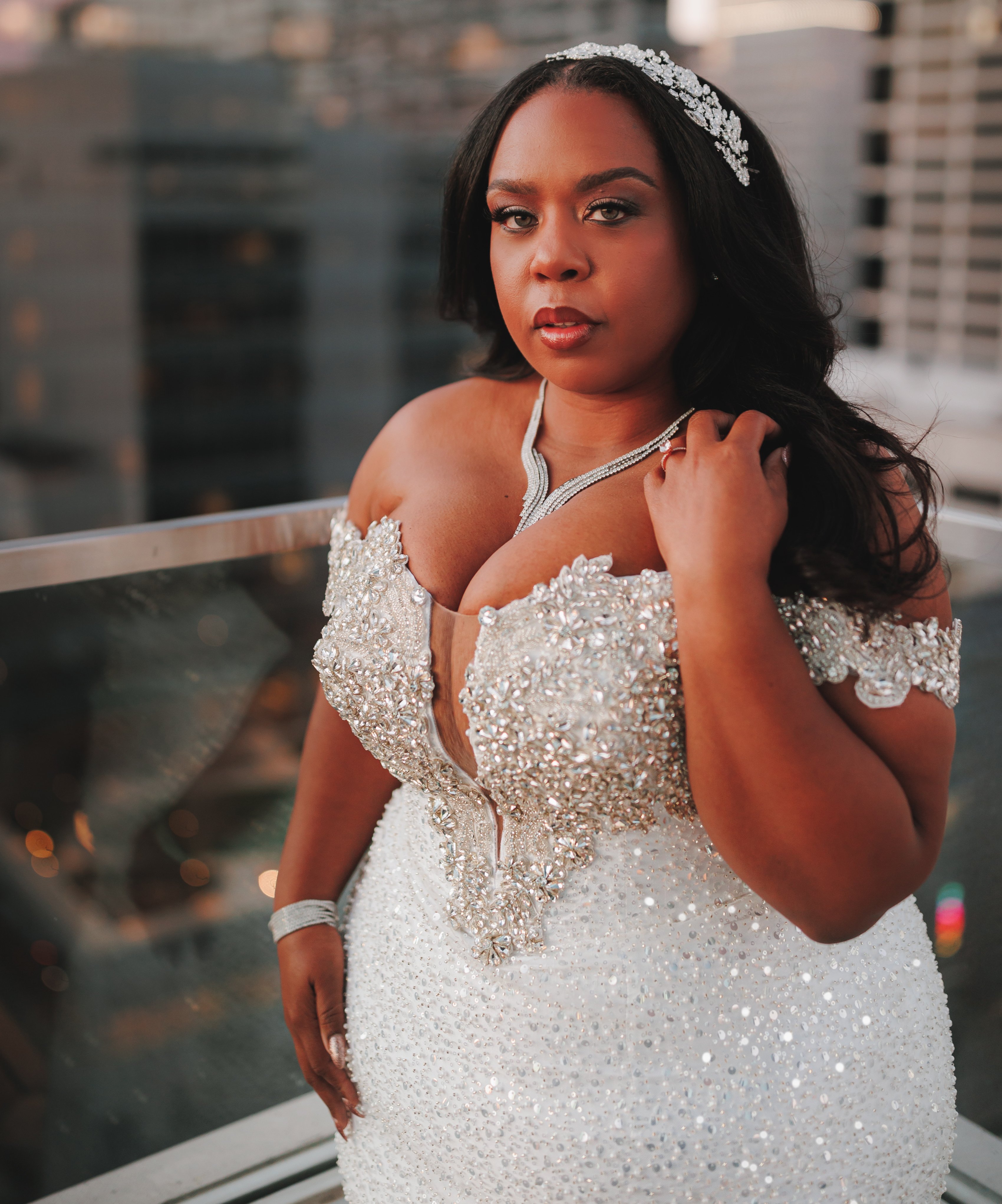 Bride, Ashley Turner poses in her off-the-shoulder wedding gown during her Houston skyline bridal shoot at sunset.