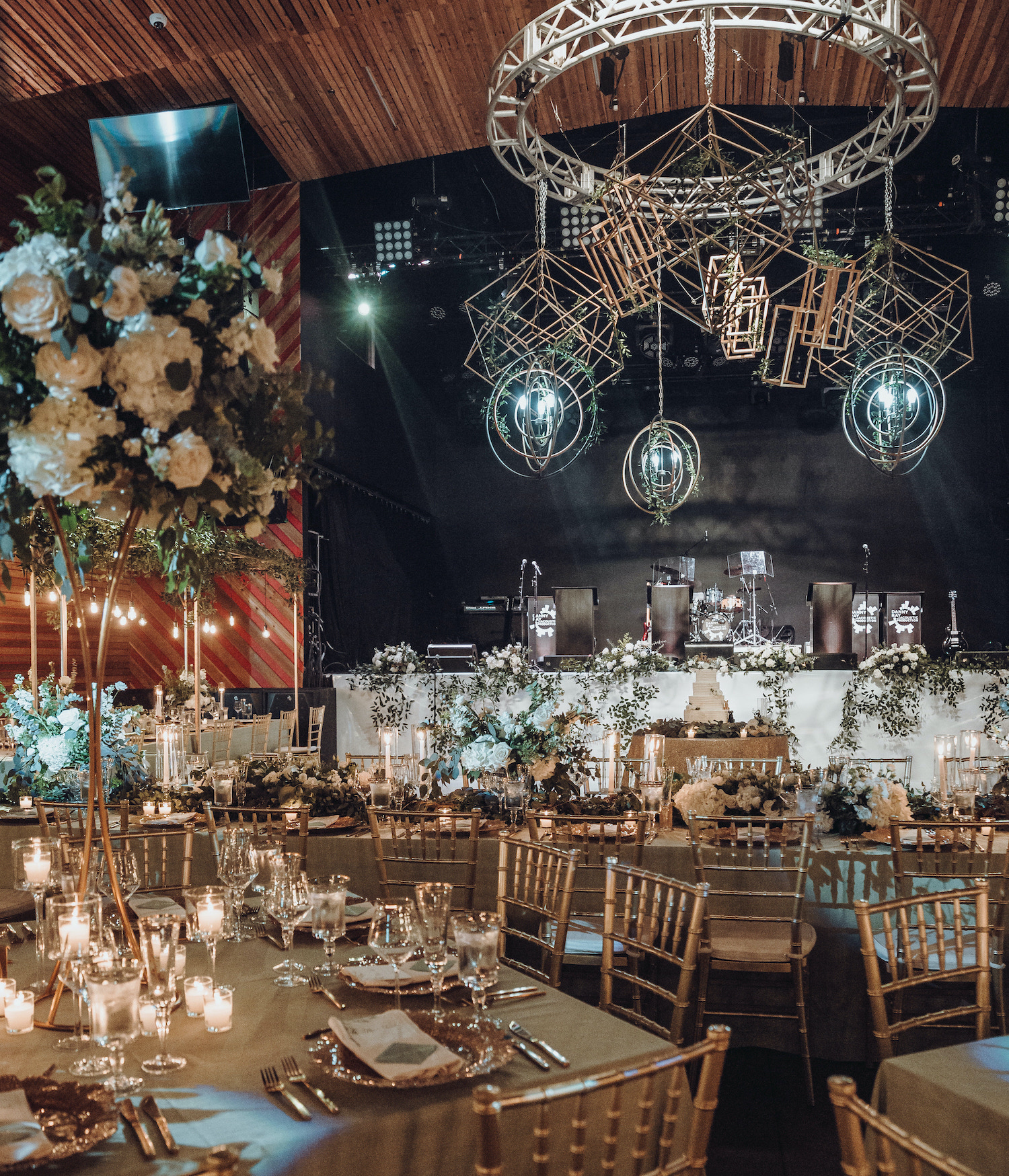 An elegant wedding reception is set up with greenery, candles and white flowers for a modern music hall wedding in Houston, TX.