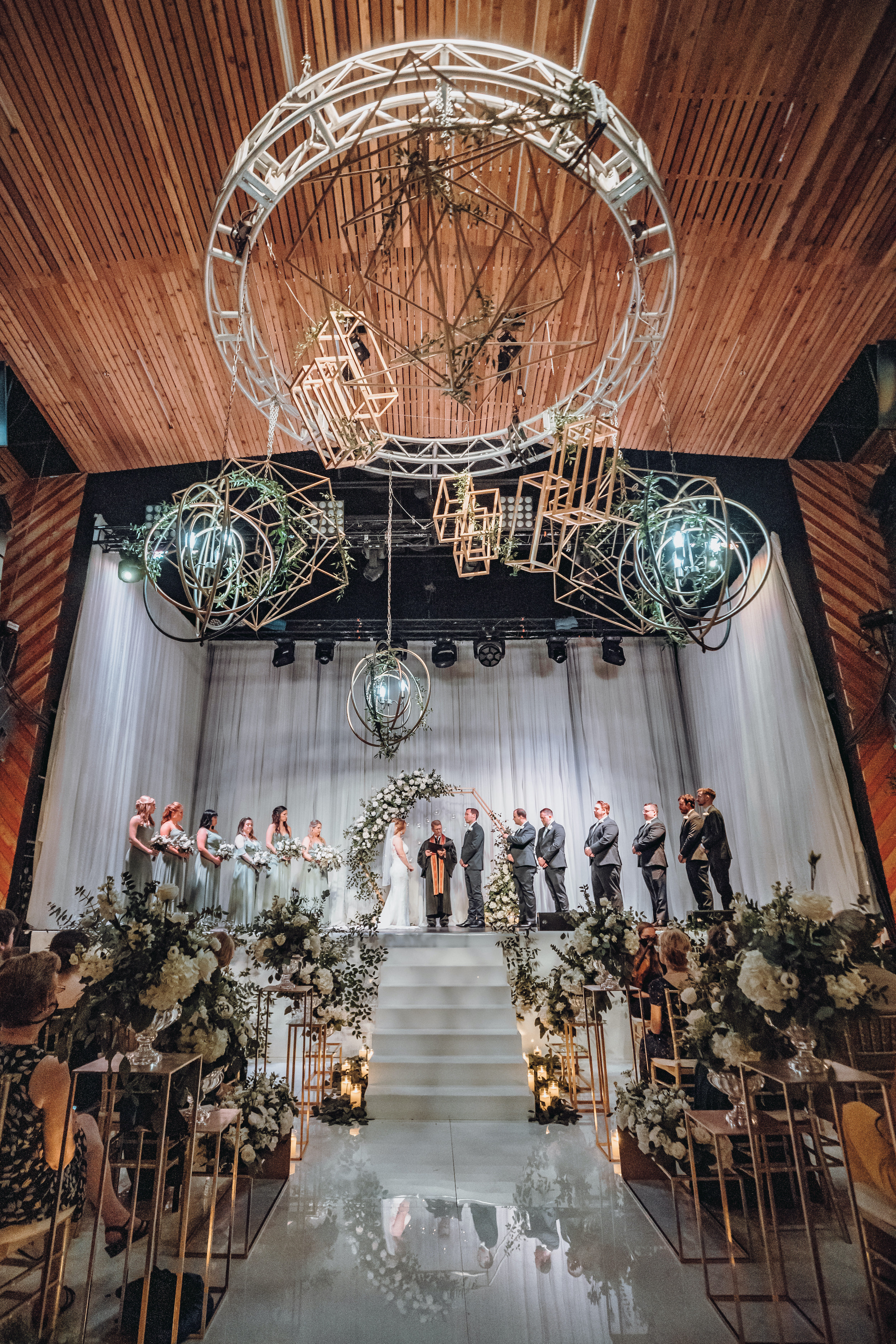 A bride and groom stand at the altar during their modern music hall wedding in Houston, TX.