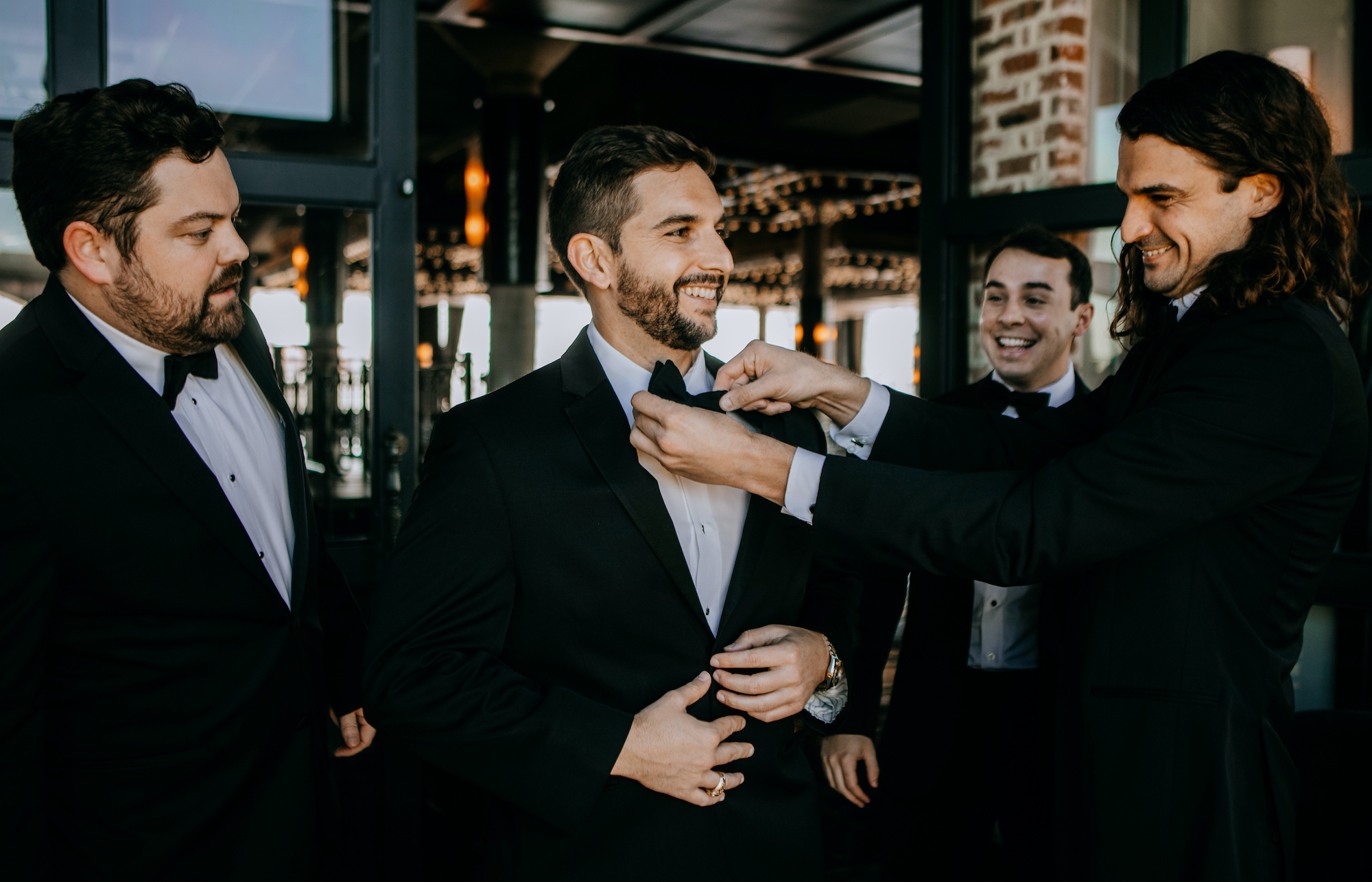 A groom smiles with his groomsmen before his wedding ceremony in Houston, TX.