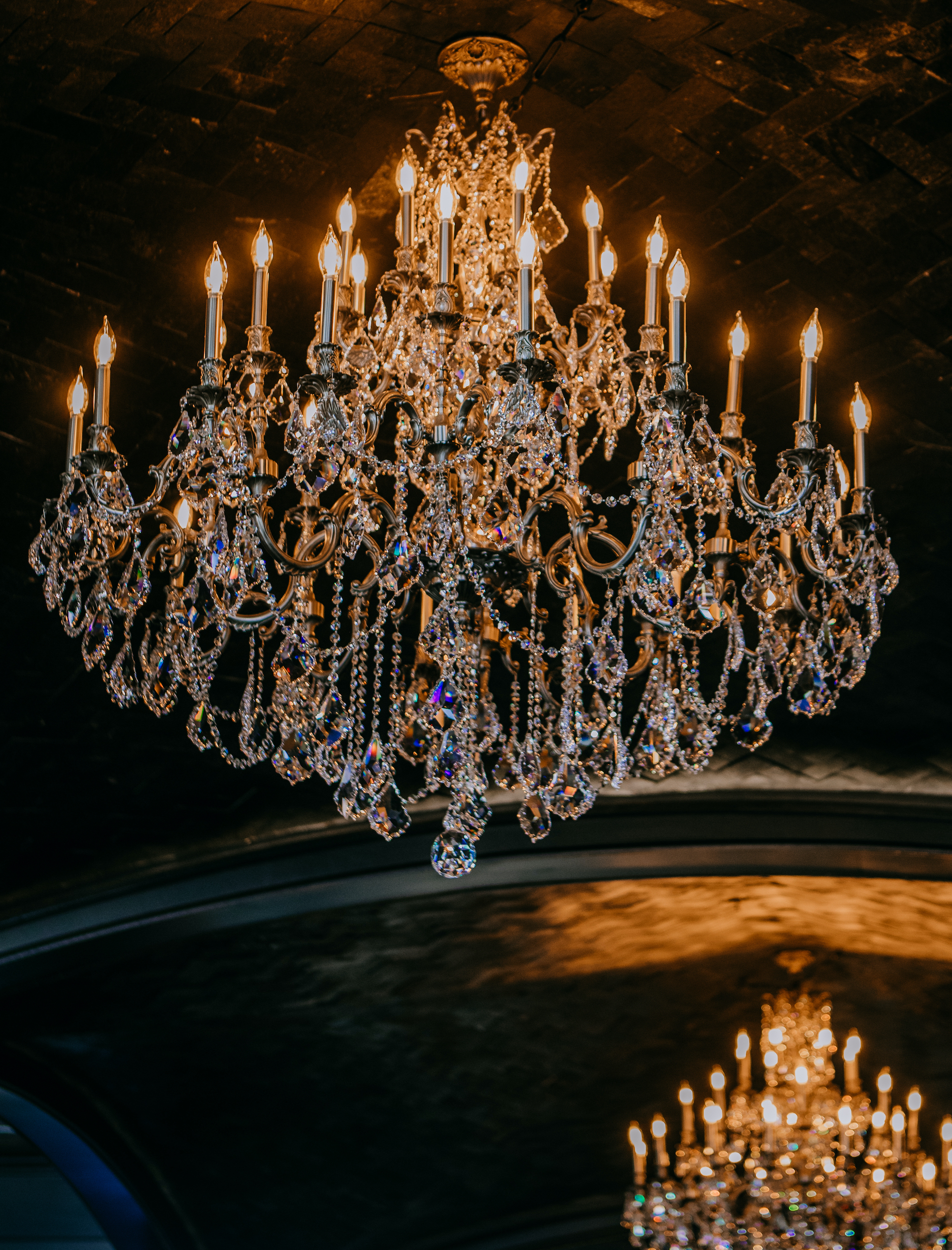 A crystal chandelier hangs from the ceiling at a Houston wedding venue.