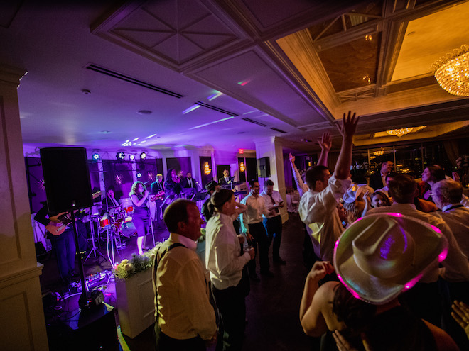 Wedding guests dancing to wedding band, The Moment, at a Houston wedding reception.