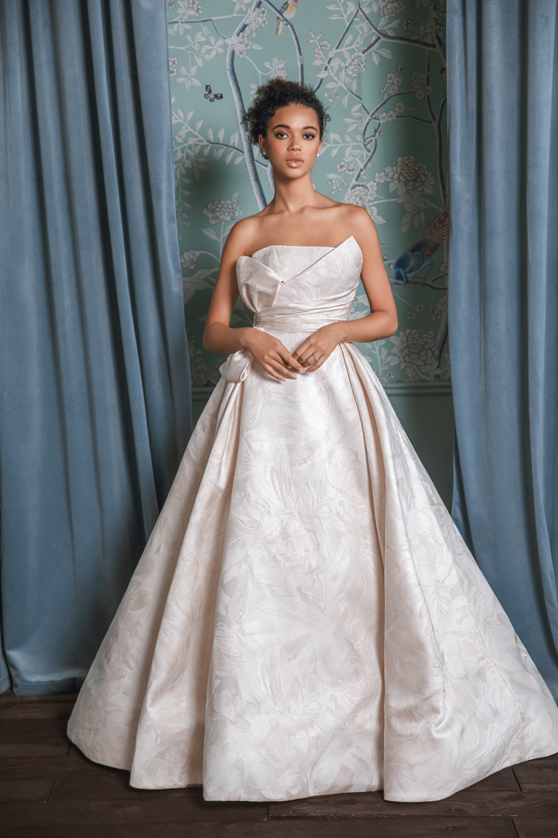 A strapless blush wedding gown with floral designs on it designed by Anne Barge for wedding gowns for the spring and summer