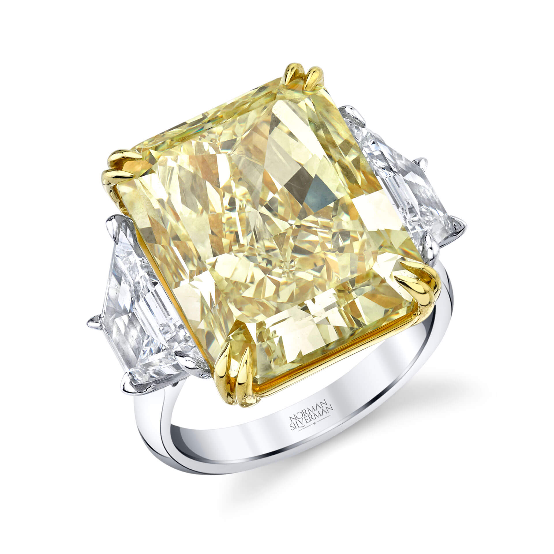 A yellow diamond ring with smaller diamonds on either side and a silver band from Norman Silverman.