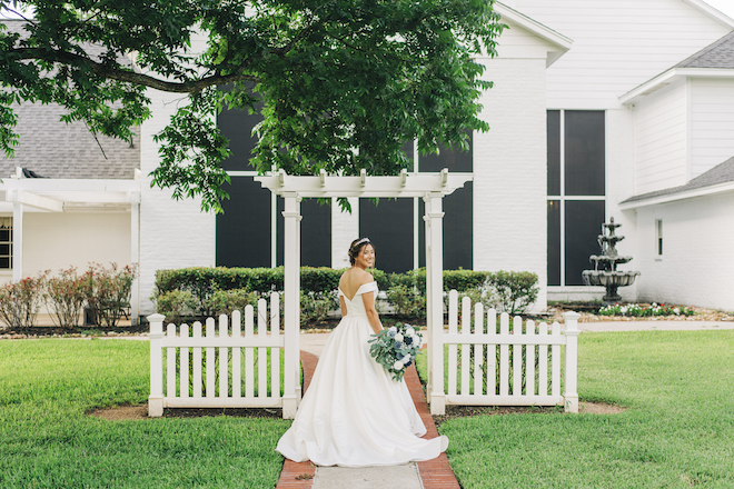 A bride standing in front of Ashelynn Manor, a wedding venue in Conroe, TX.