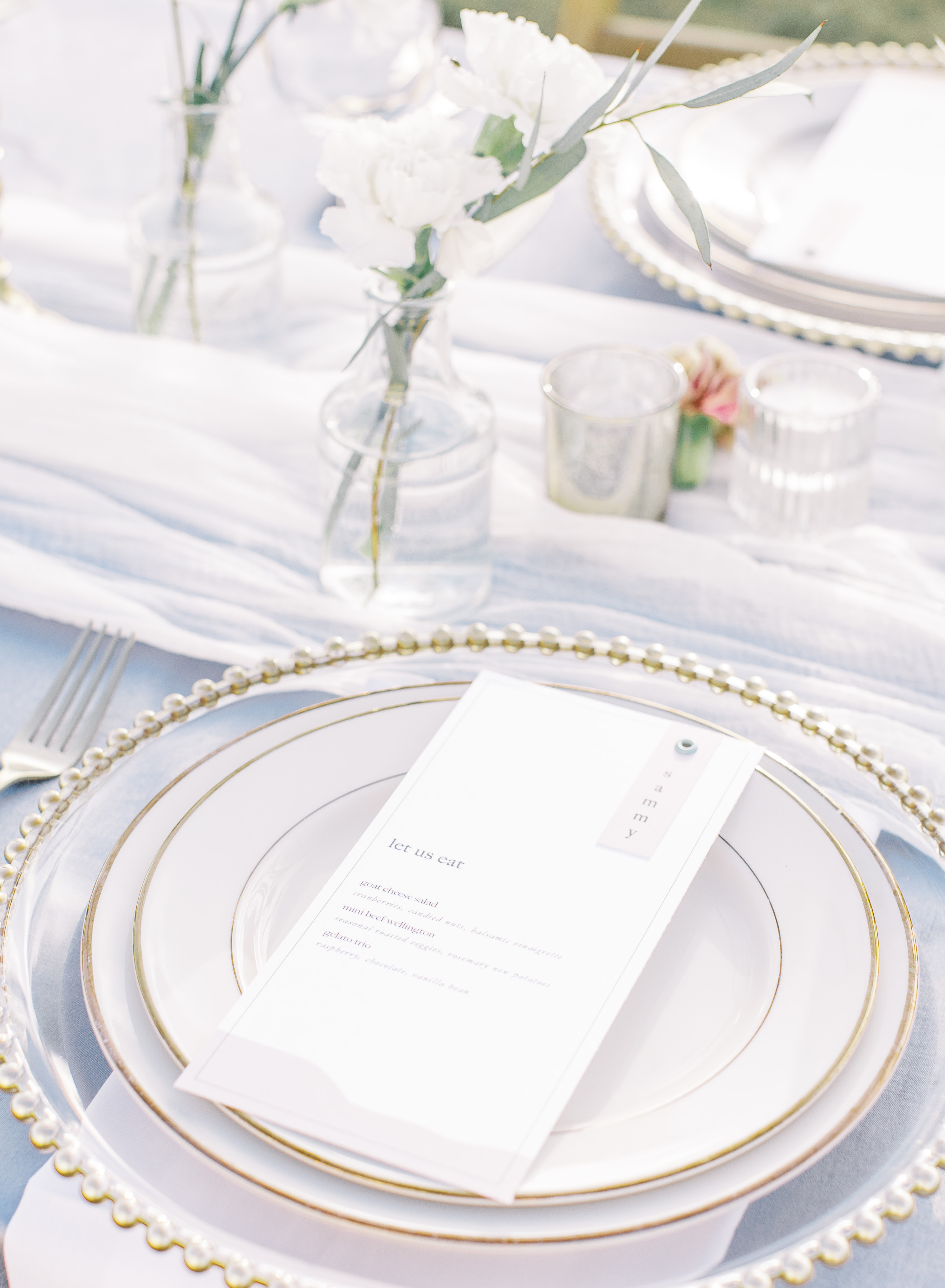 A wedding dinner menu is set on a plate for an alfresco wedding reception in the Texas Hill Country.