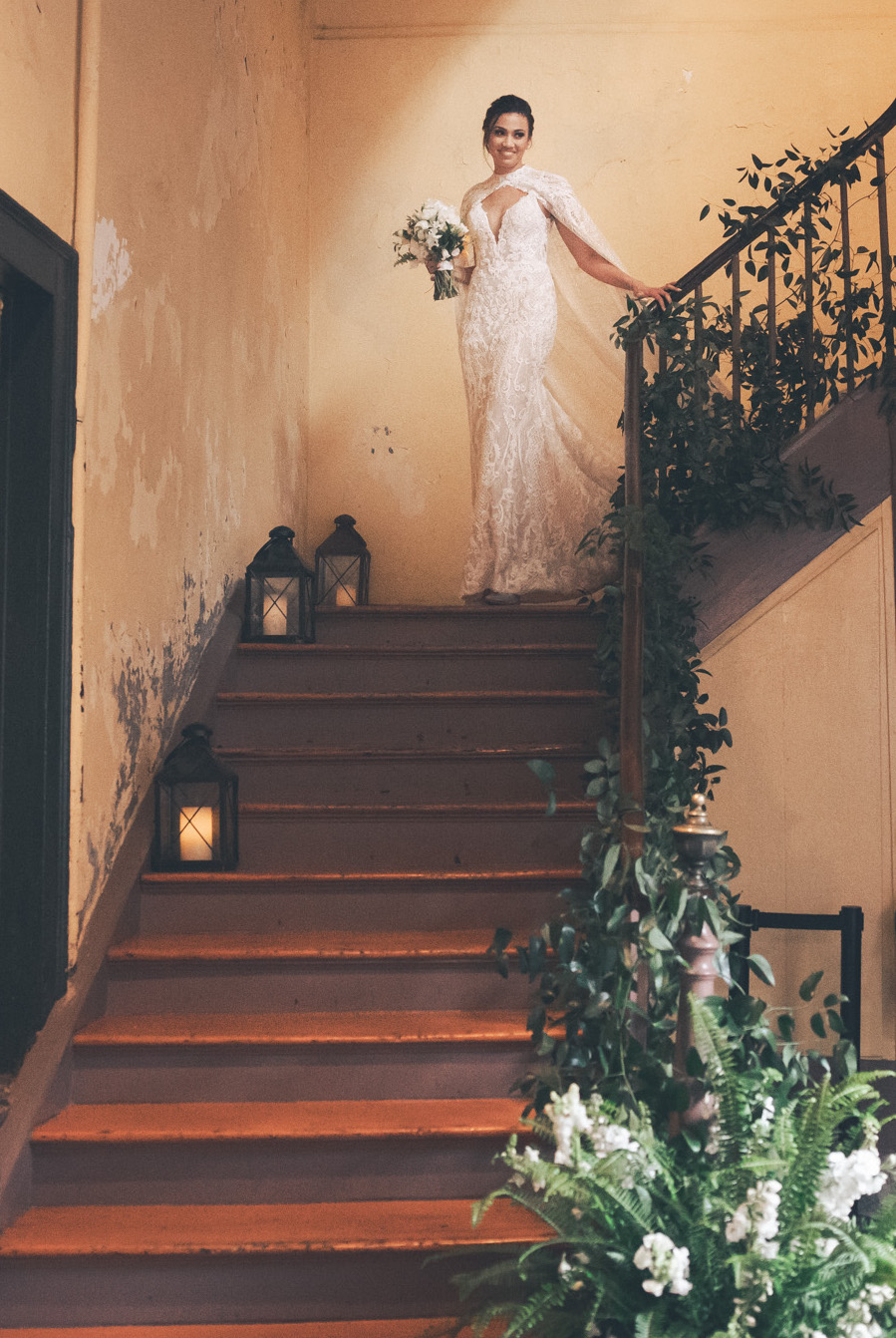A bride walks down the stairs in her wedding dress for her NOLA destination wedding.