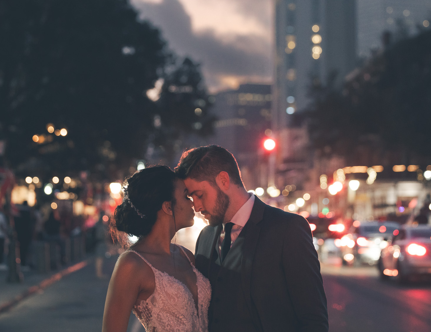 A bride and groom embrace in the street during their wedding day in New Orleans.