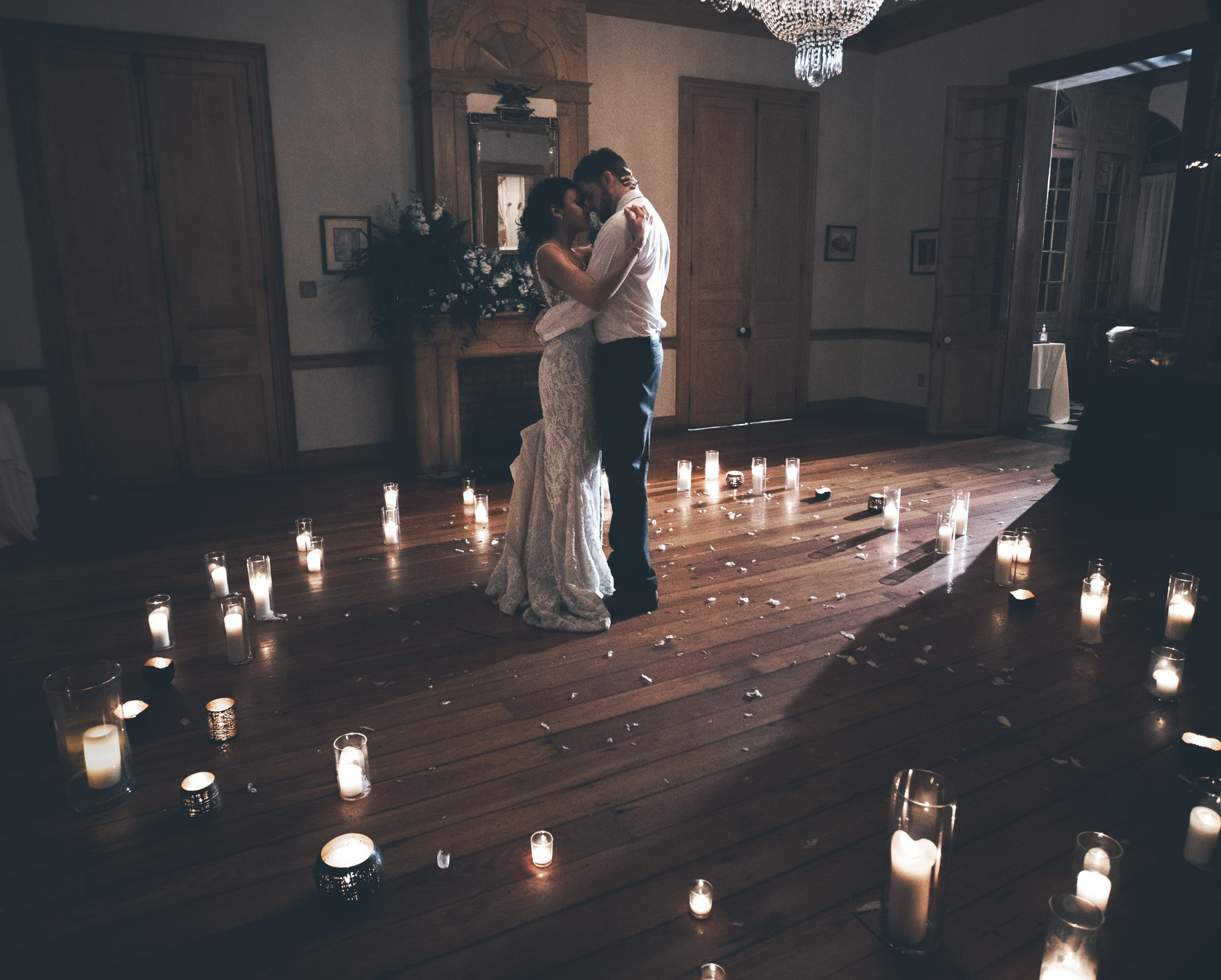 A bride and groom dance in a room lit with candles during their NOLA destination wedding.