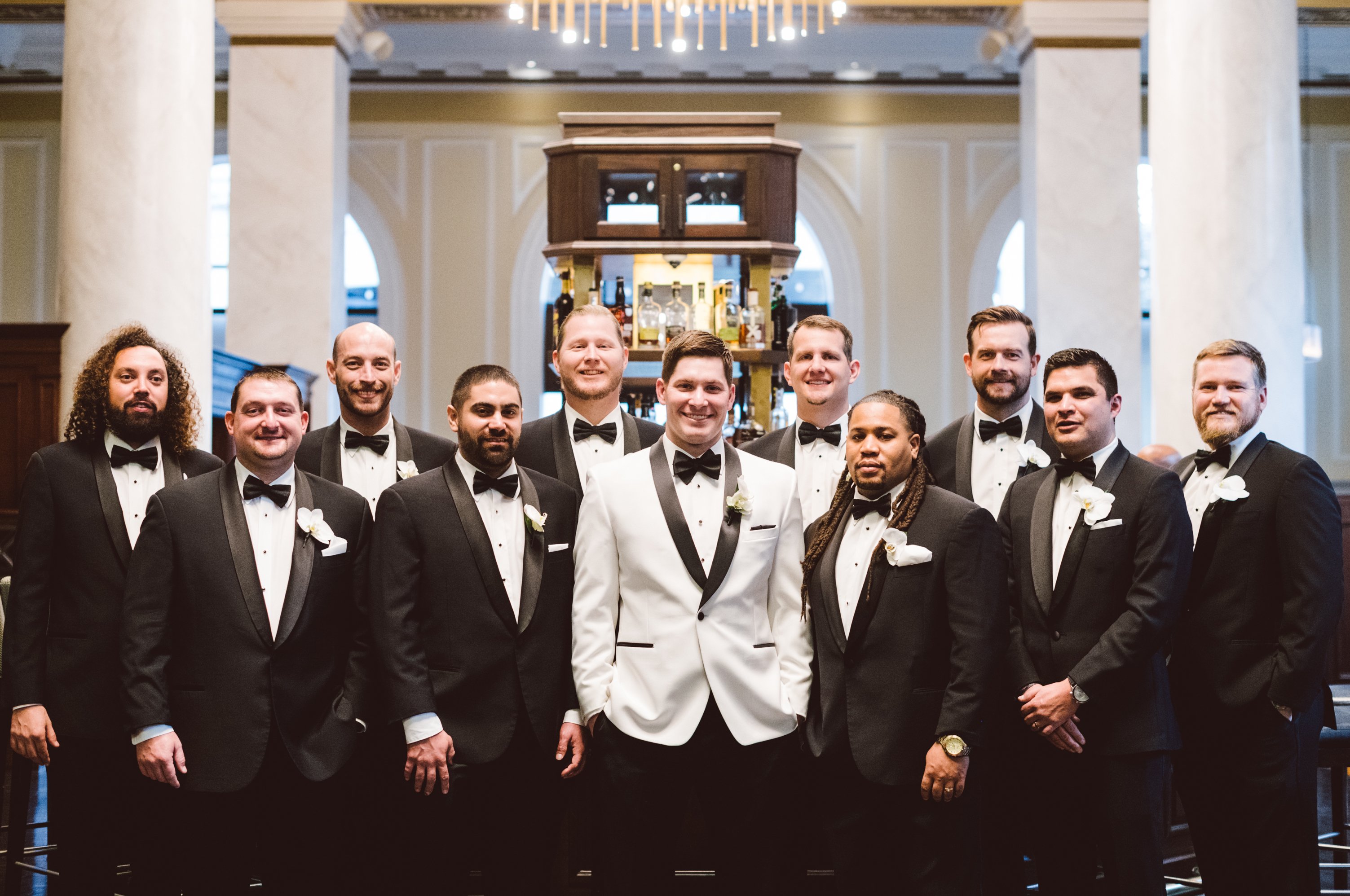 A groom poses with his groomsmen at Hotel Icon in Houston, TX for his opulent winter wedding.