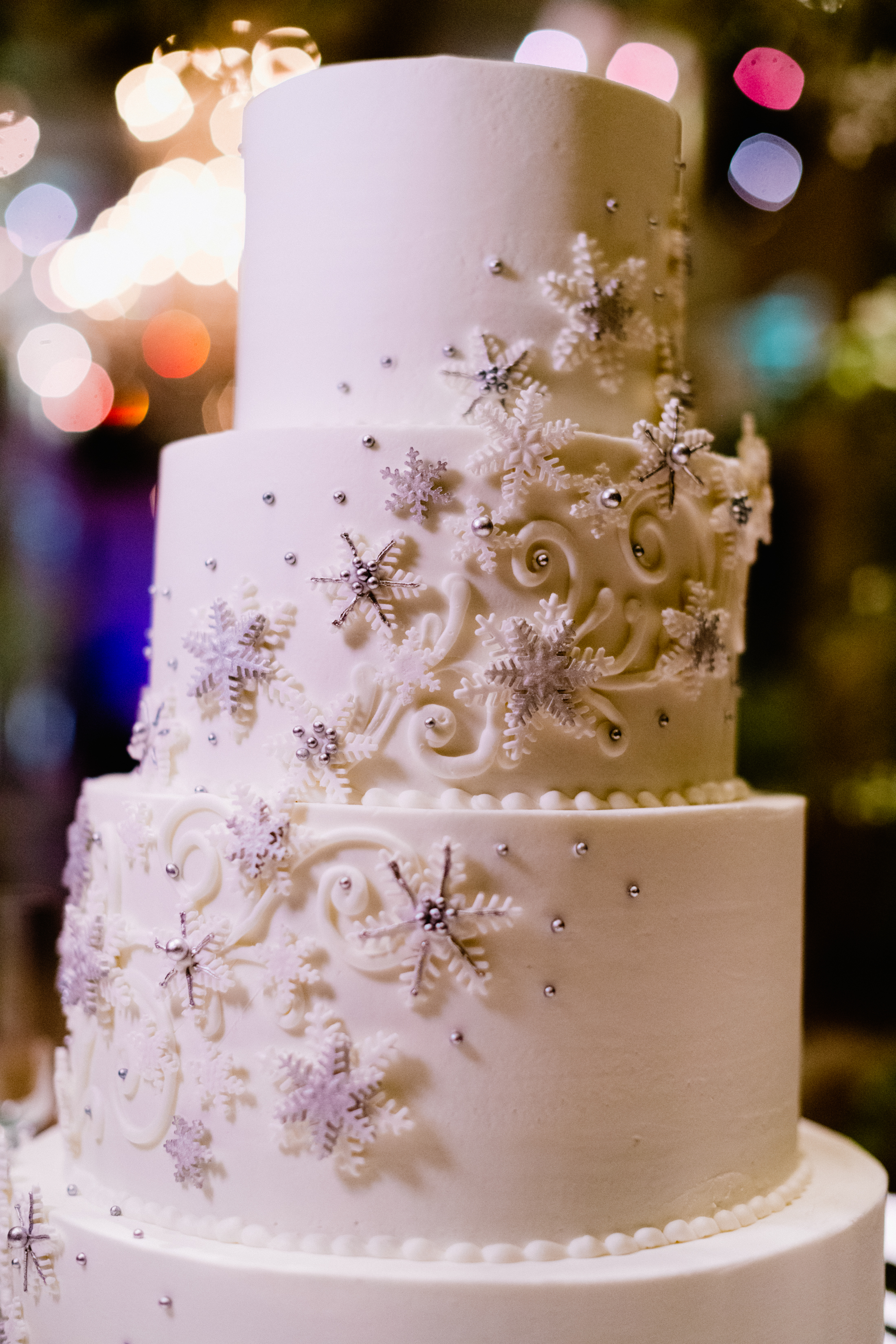 A white wedding cake with snowflake details for an opulent winter wedding.