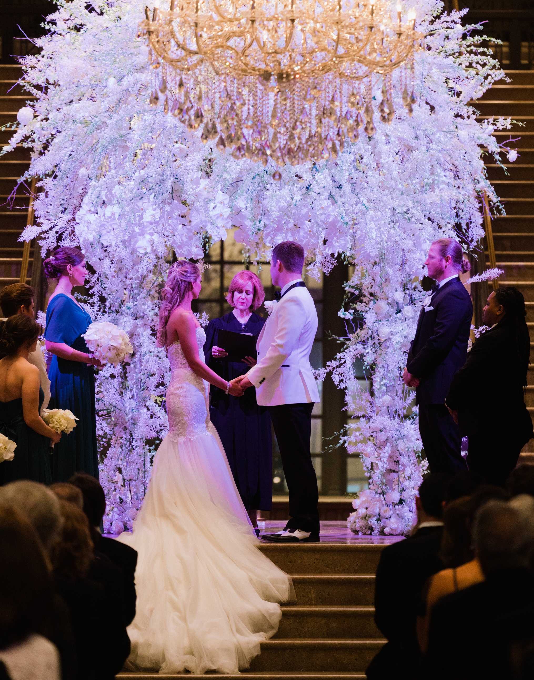 A bride and groom stand at the altar holding hands during their wedding ceremony in Houston at Corinthian Houston.