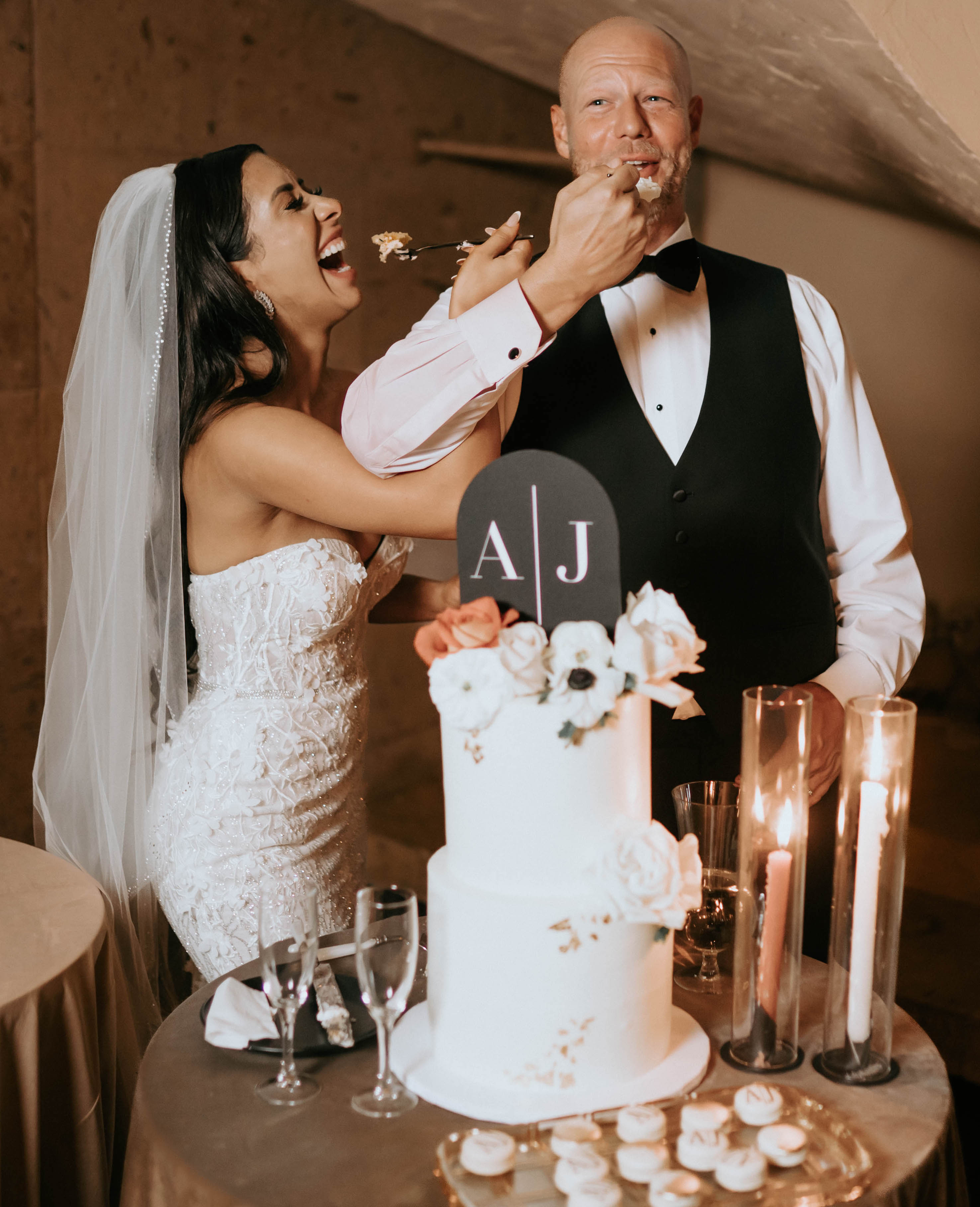 A bride and groom give each other a bite of their wedding cake at their earth-toned wedding at The Bell Tower on 34th in Houston, TX.