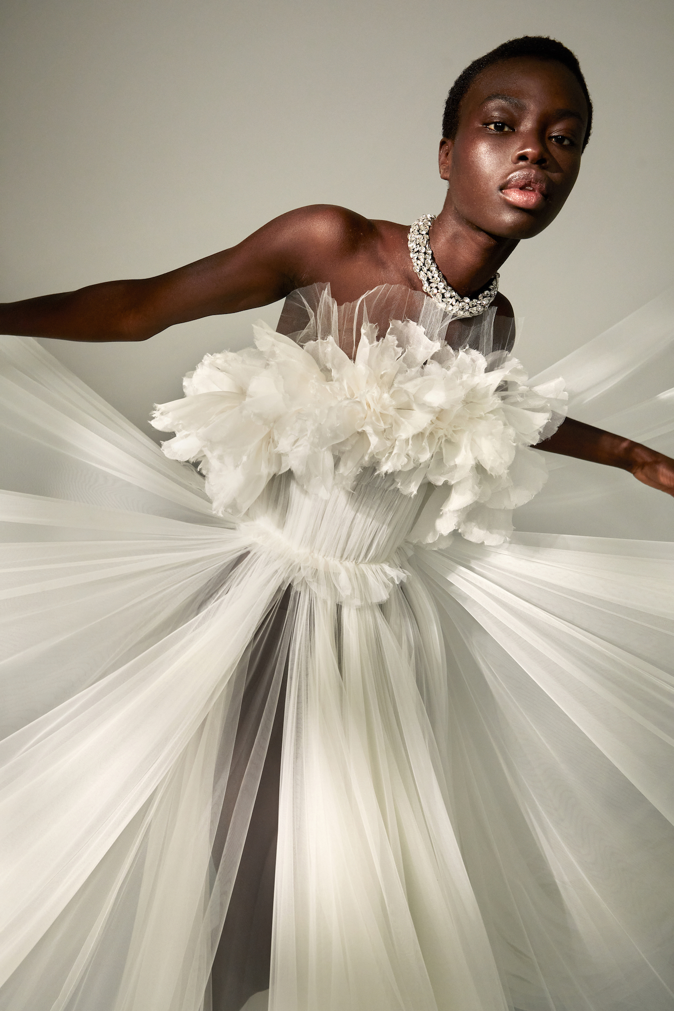A bride wears a strapless designer wedding dress with ruffles and flowers. Kaviar Gauche.