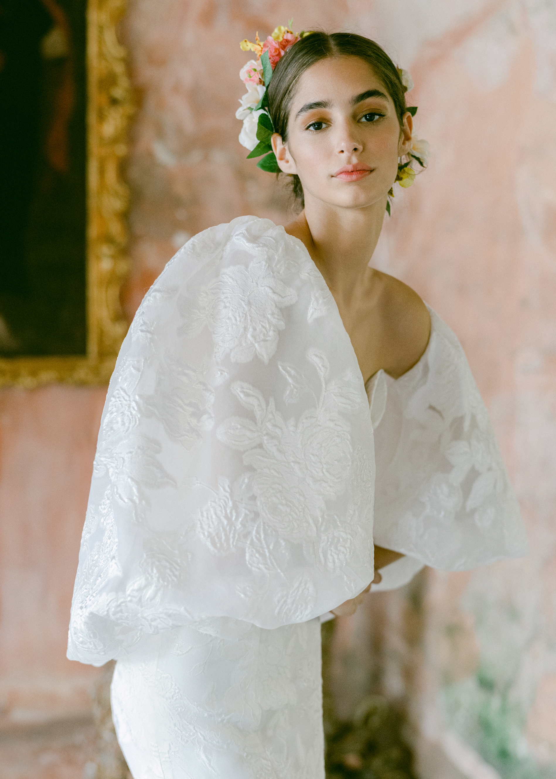 A bride wears a Monique Lhuillier dress with puff sleeves and embellished flowers.