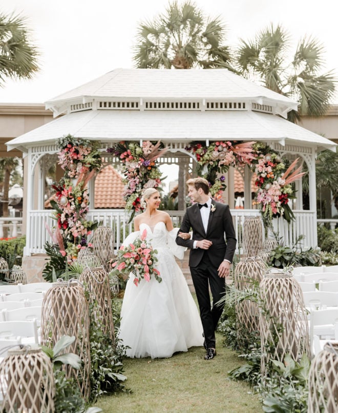 Bride and groom walk down the aisle at a gazebo outside of San Luis Resort, Spa and Conference Center in Galveston. 
