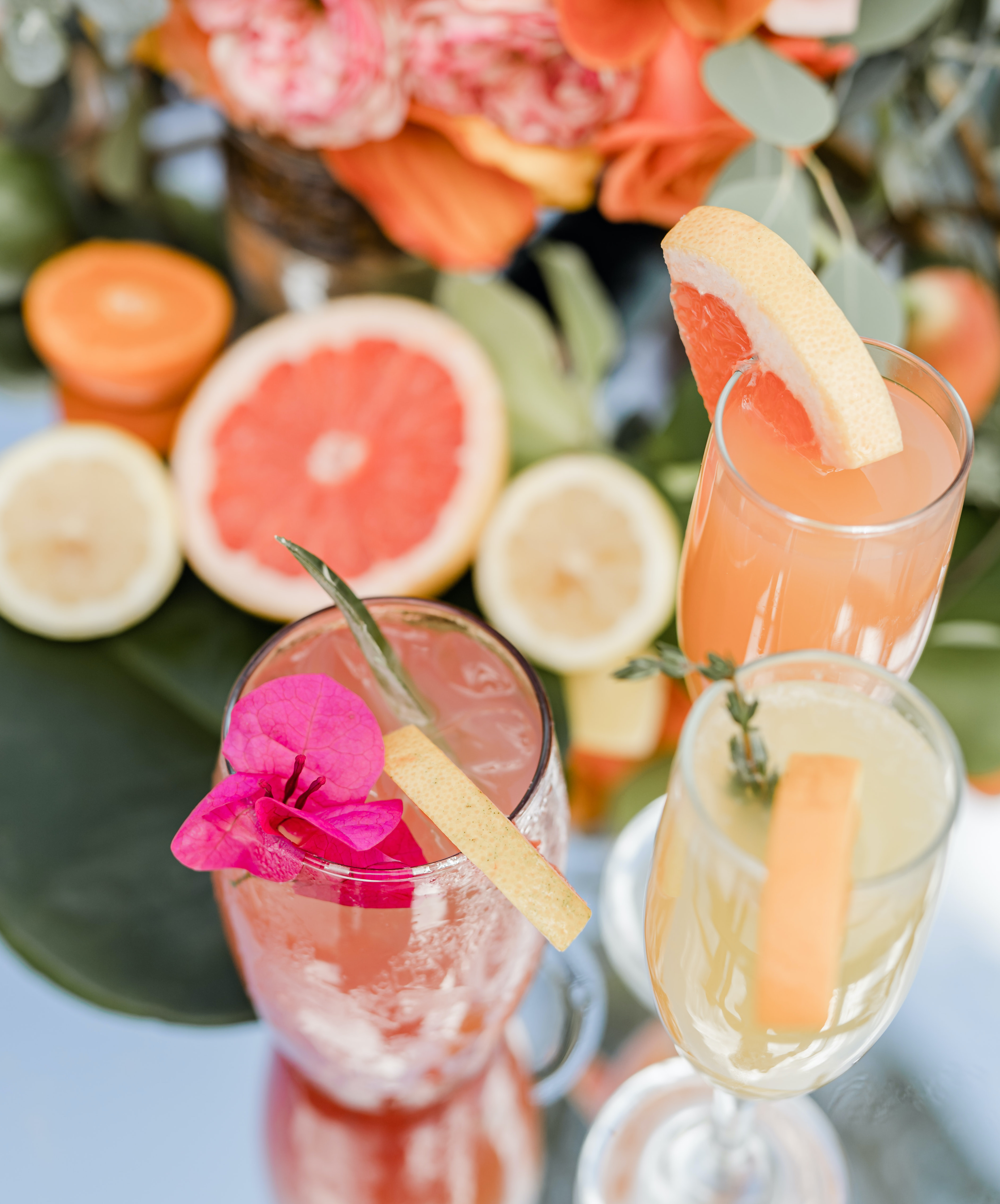 Three colorful summer cocktails are on a cocktail cart for a tropical luxe beachfront editorial.