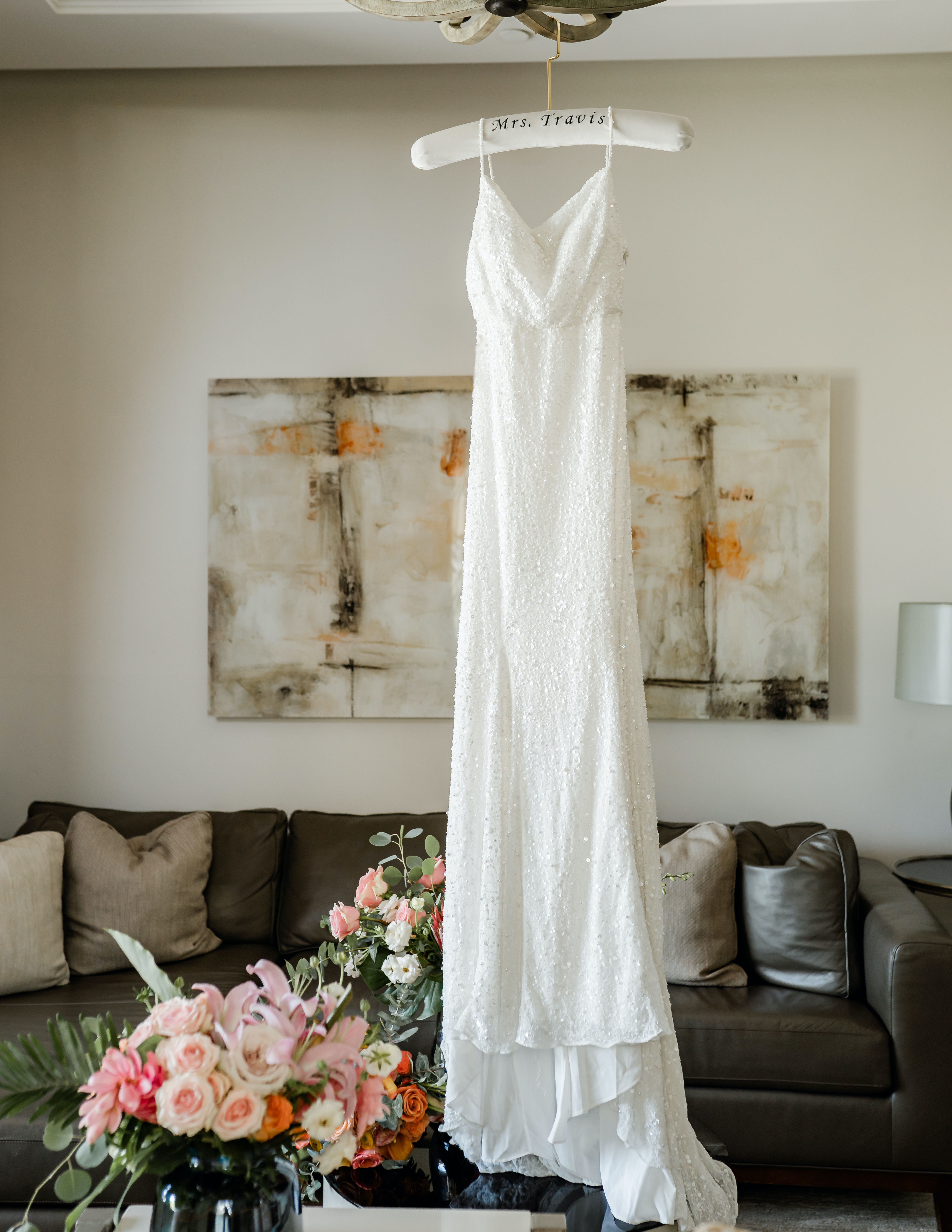 A sparkling sequin bridal gown is hanging from a velvet hanger in a pool villa at The San Luis Resort, Spa & Conference Center on Galveston, Island.