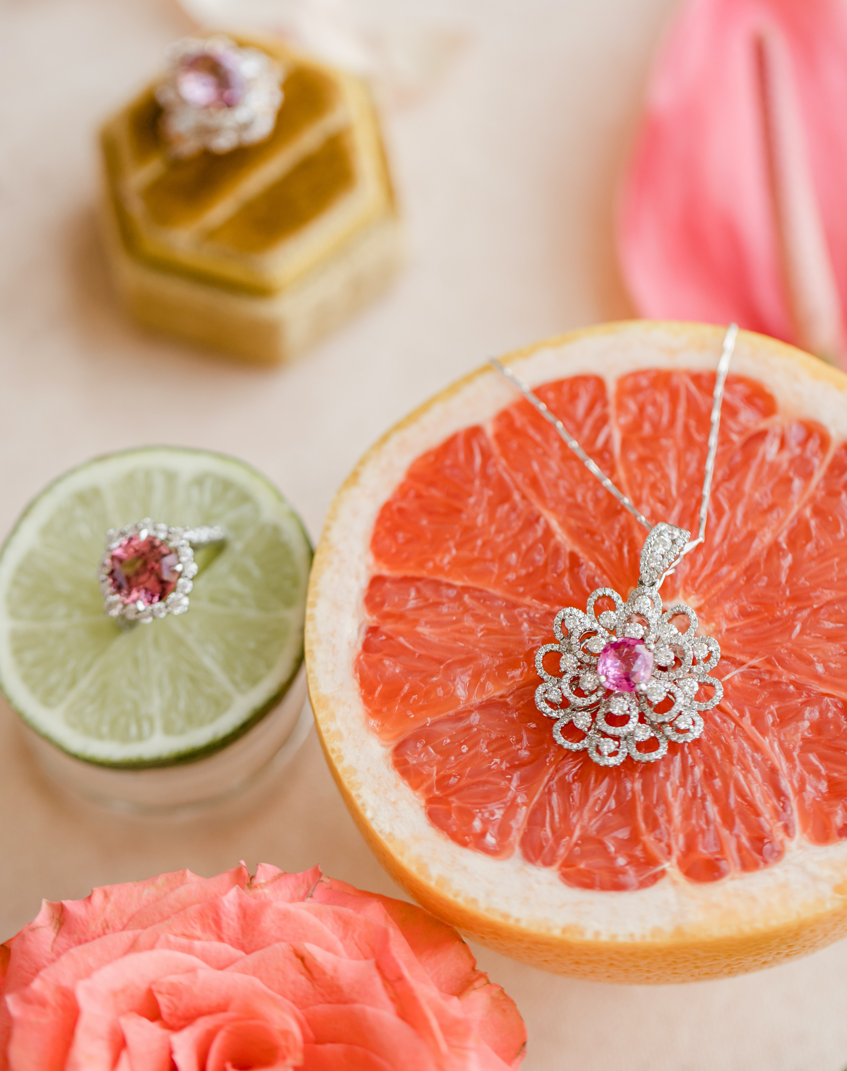 Luxury jewelry from Houston jeweler, Shaftel Diamonds is propped on a grapefruit and lime during a tropical luxe beachfront wedding editorial in Galveston, TX.