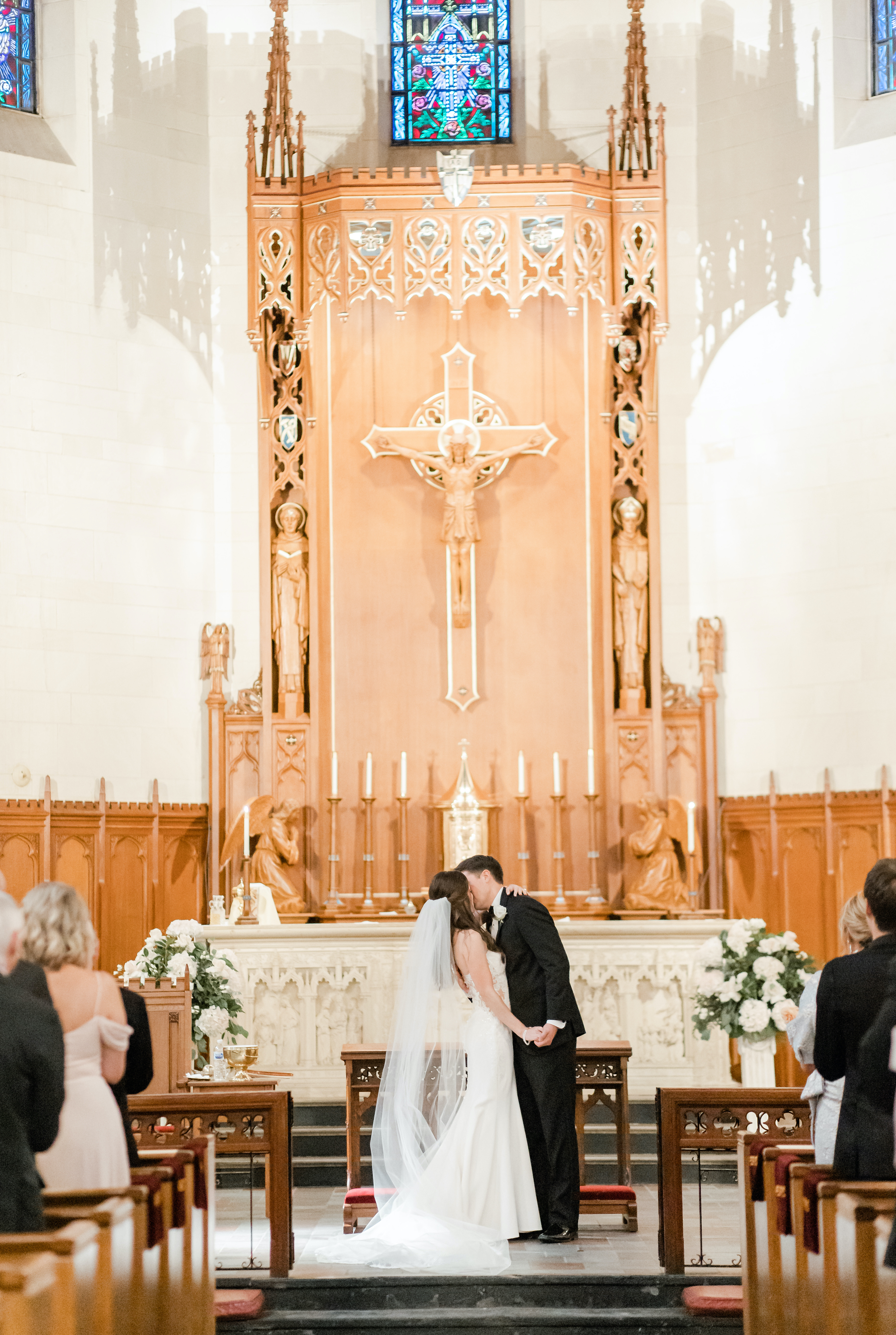 A bride and groom kiss at the altar during their wedding in Houston.