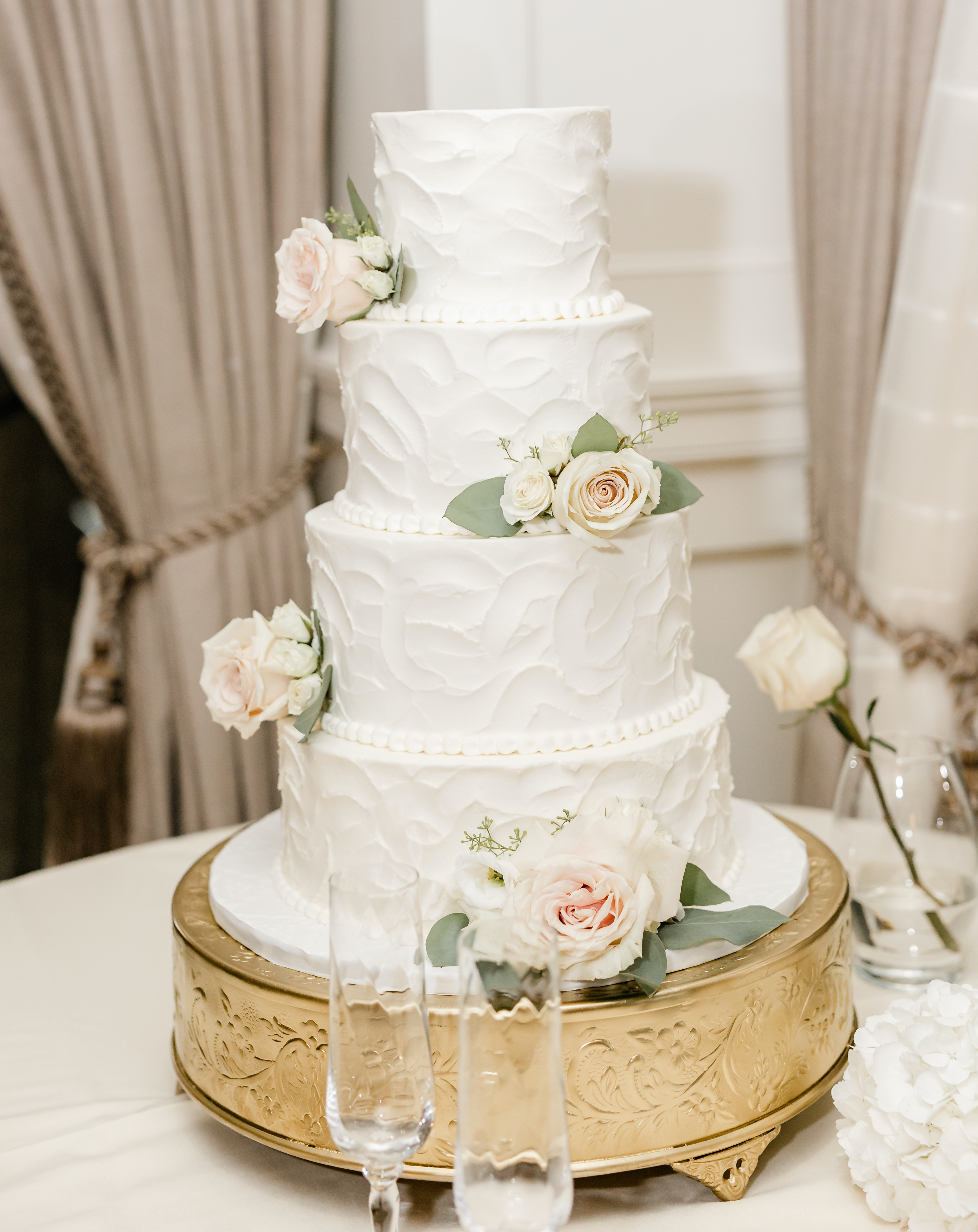A bride and groom's blush and sage wedding cake with four-tiers at The Petroleum Club of Houston.