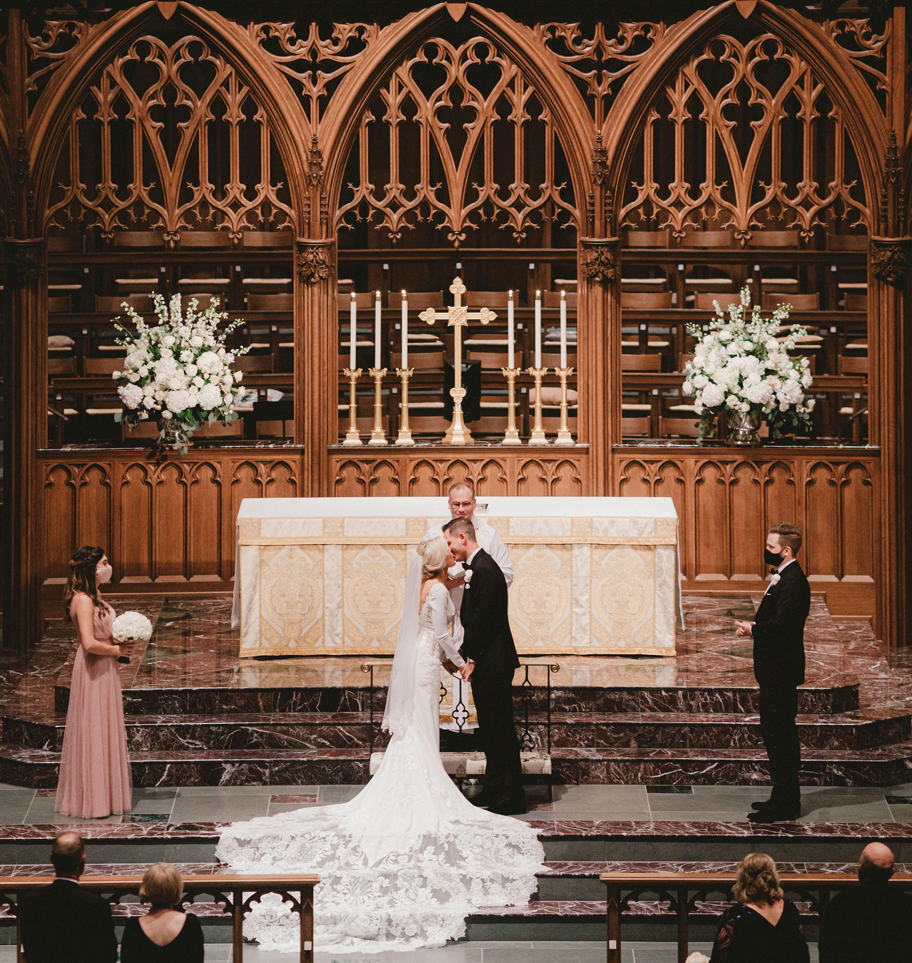 A bride and groom kiss at the altar during their wedding ceremony in Houston.