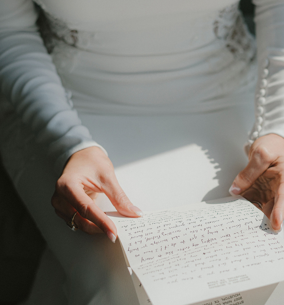 An up close photo of a bride's hands holding a letter from her groom before their wedding in Houston.