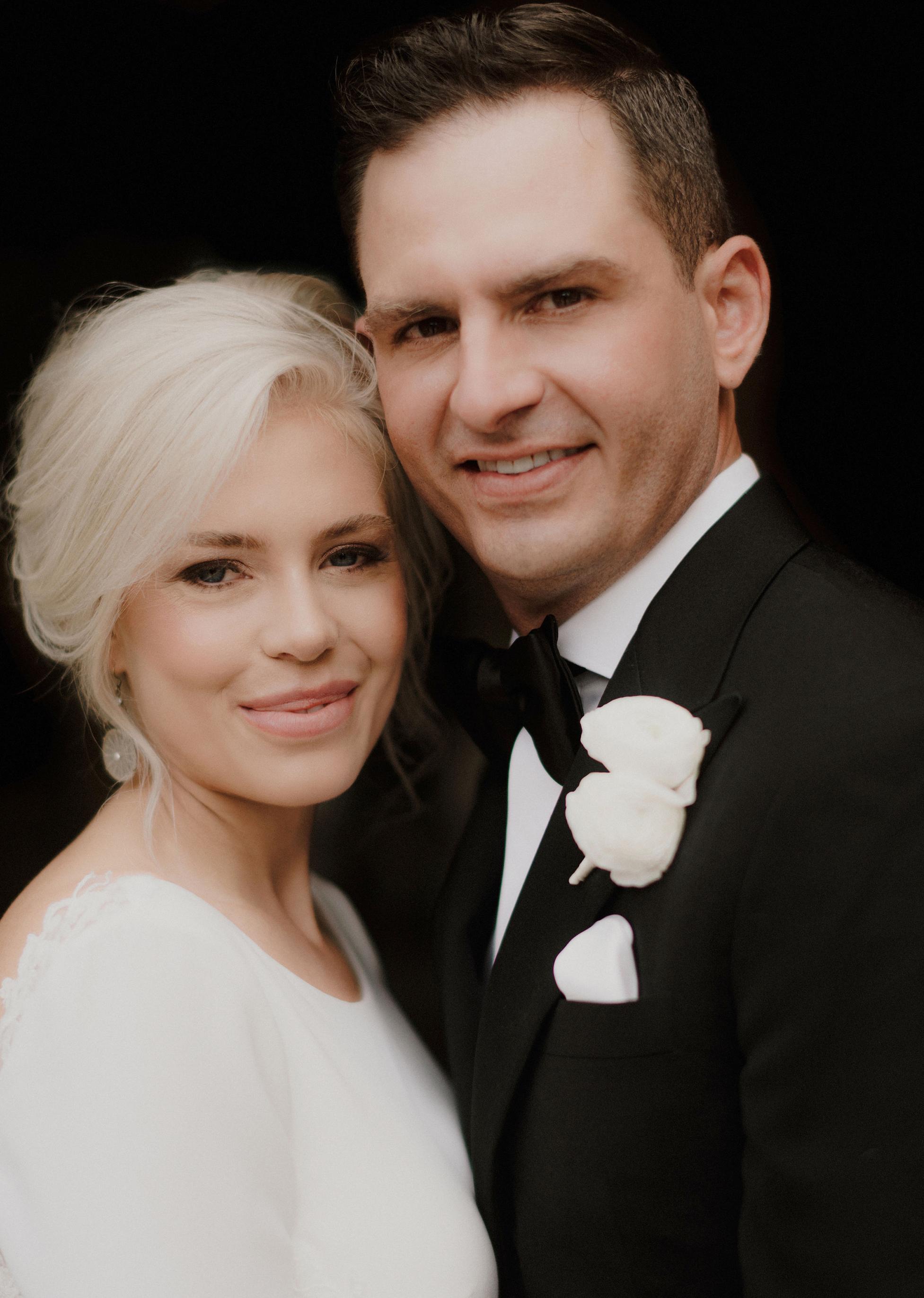 A bride and groom smile at the camera after their wedding ceremony in Houston.