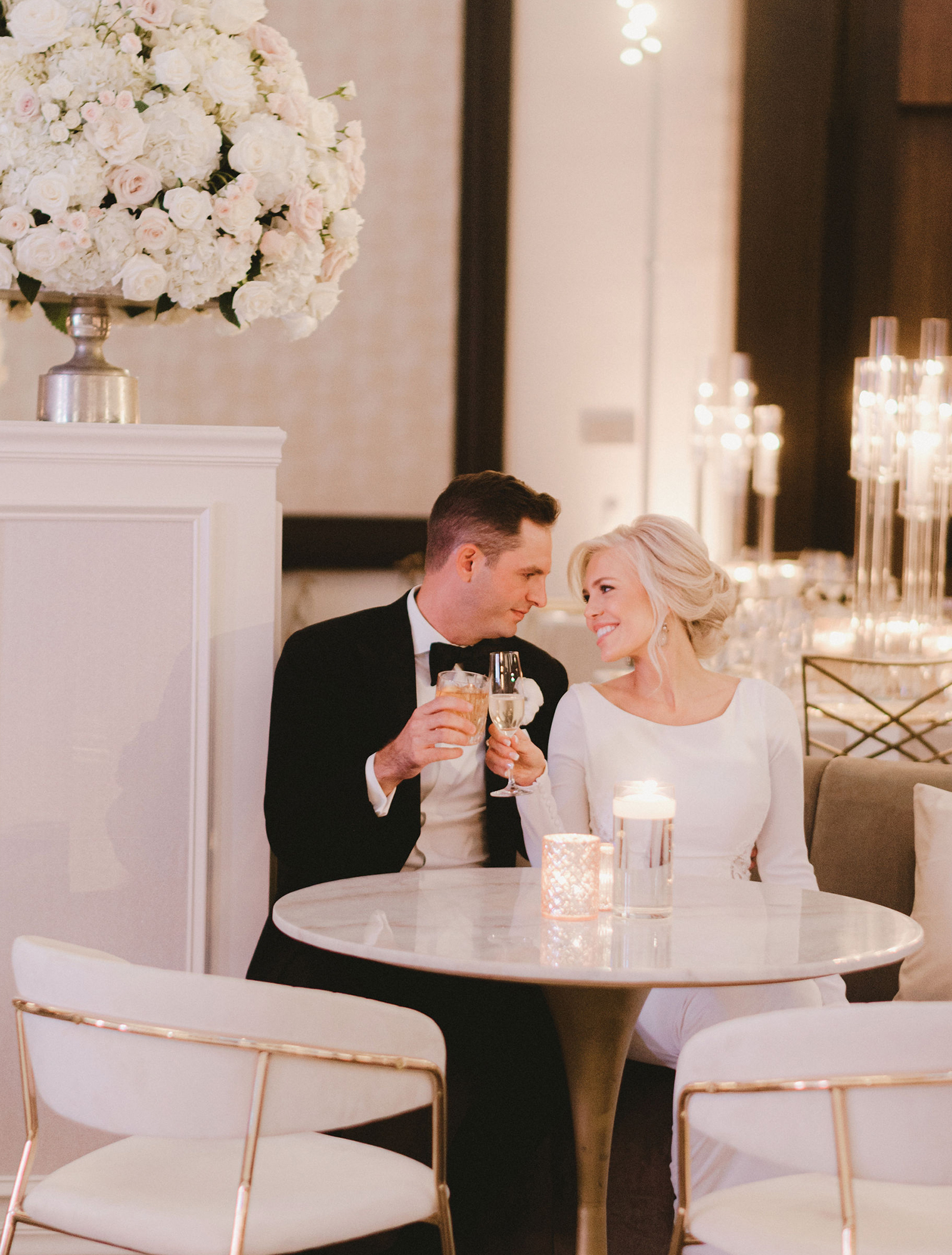 A bride and groom cheers in the ballroom before their wedding reception in Houston.