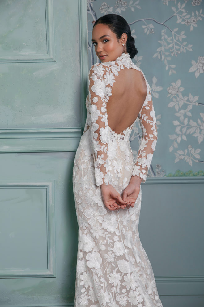 Woman wearing a floral lace wedding gown with an open back by Anne Barge.