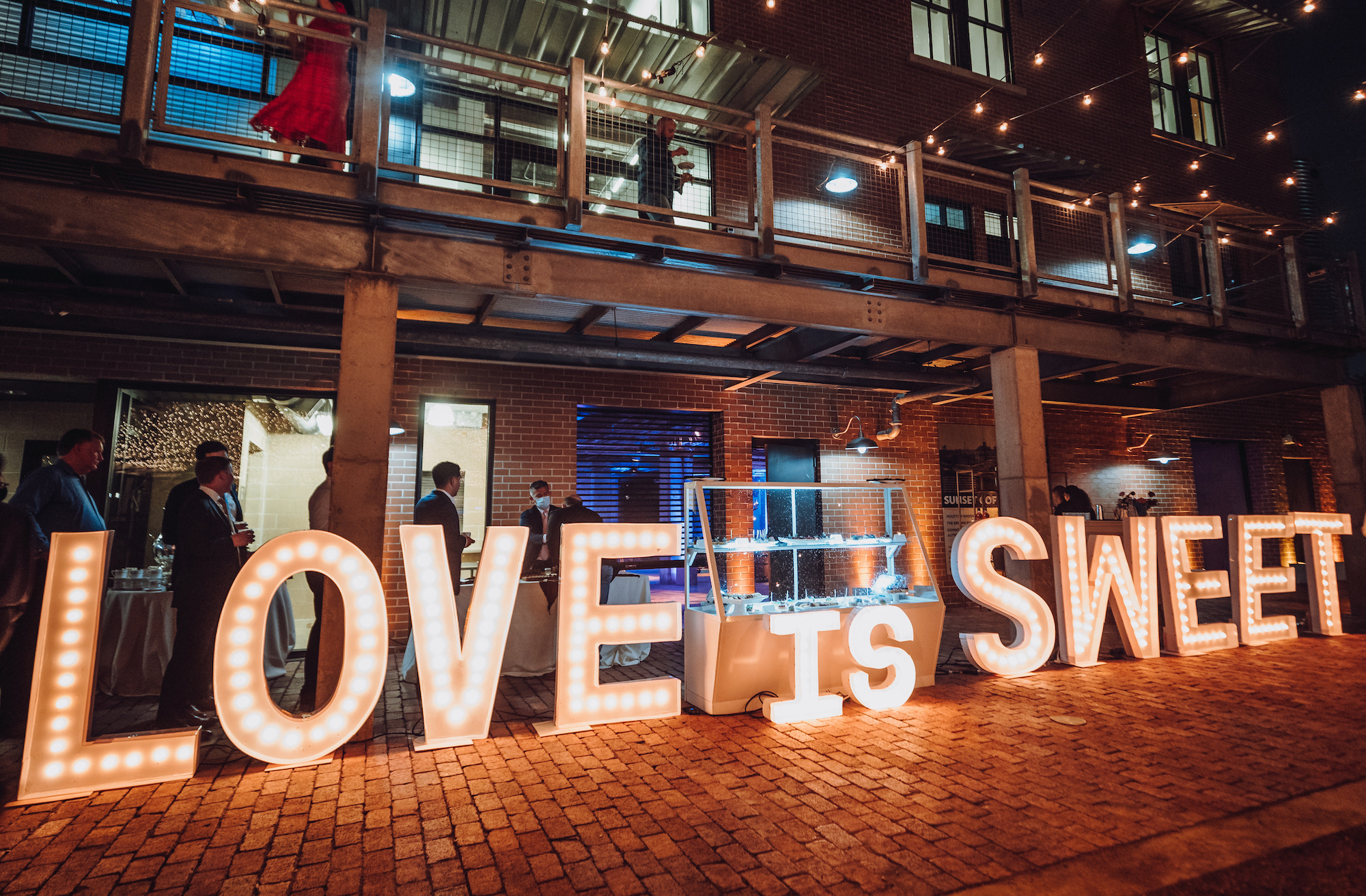 An LED sign that says "Love is Sweet" is set up outside a wedding reception in Houston.