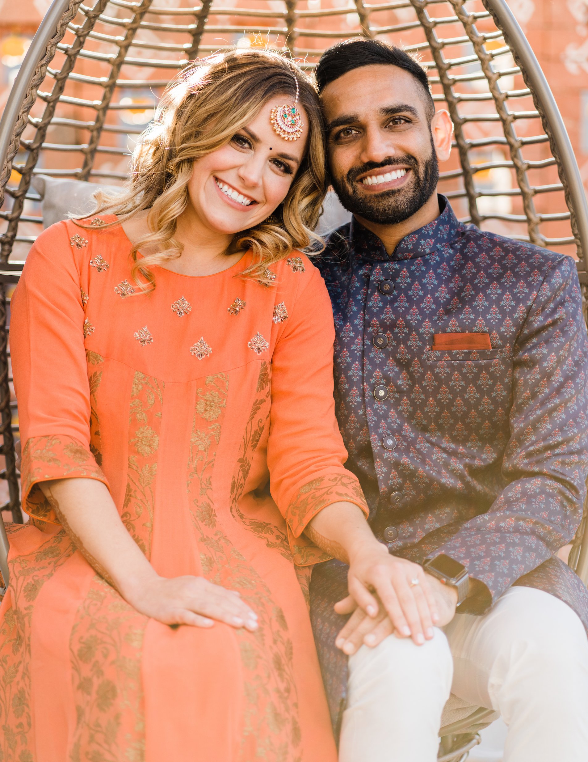 Bride and groom smile wearing traditional Indian wedding attire for their Hindu ceremony. 