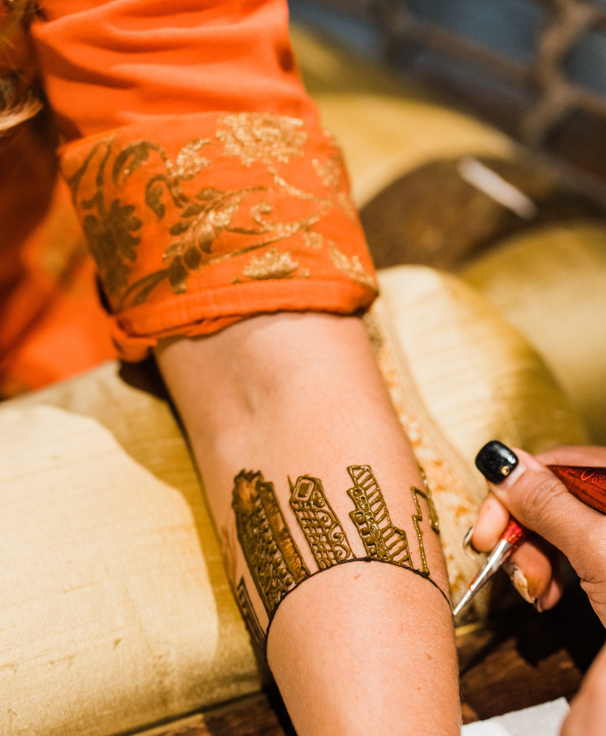 The bride receives a henna tattoo of the Houston skyline. 