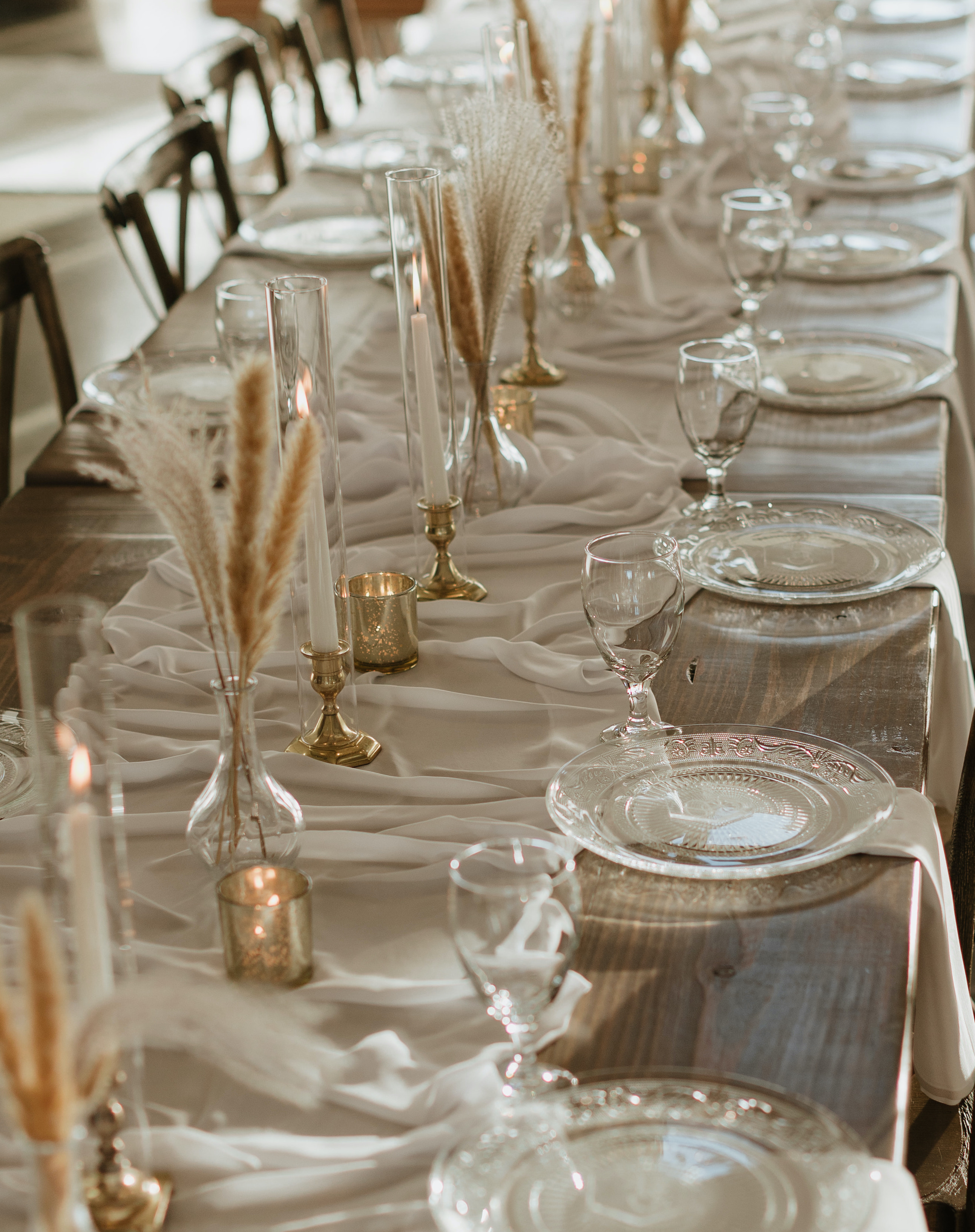 A reception table is set with dried florals and taper candles. Peach-Toned Countryside wedding.