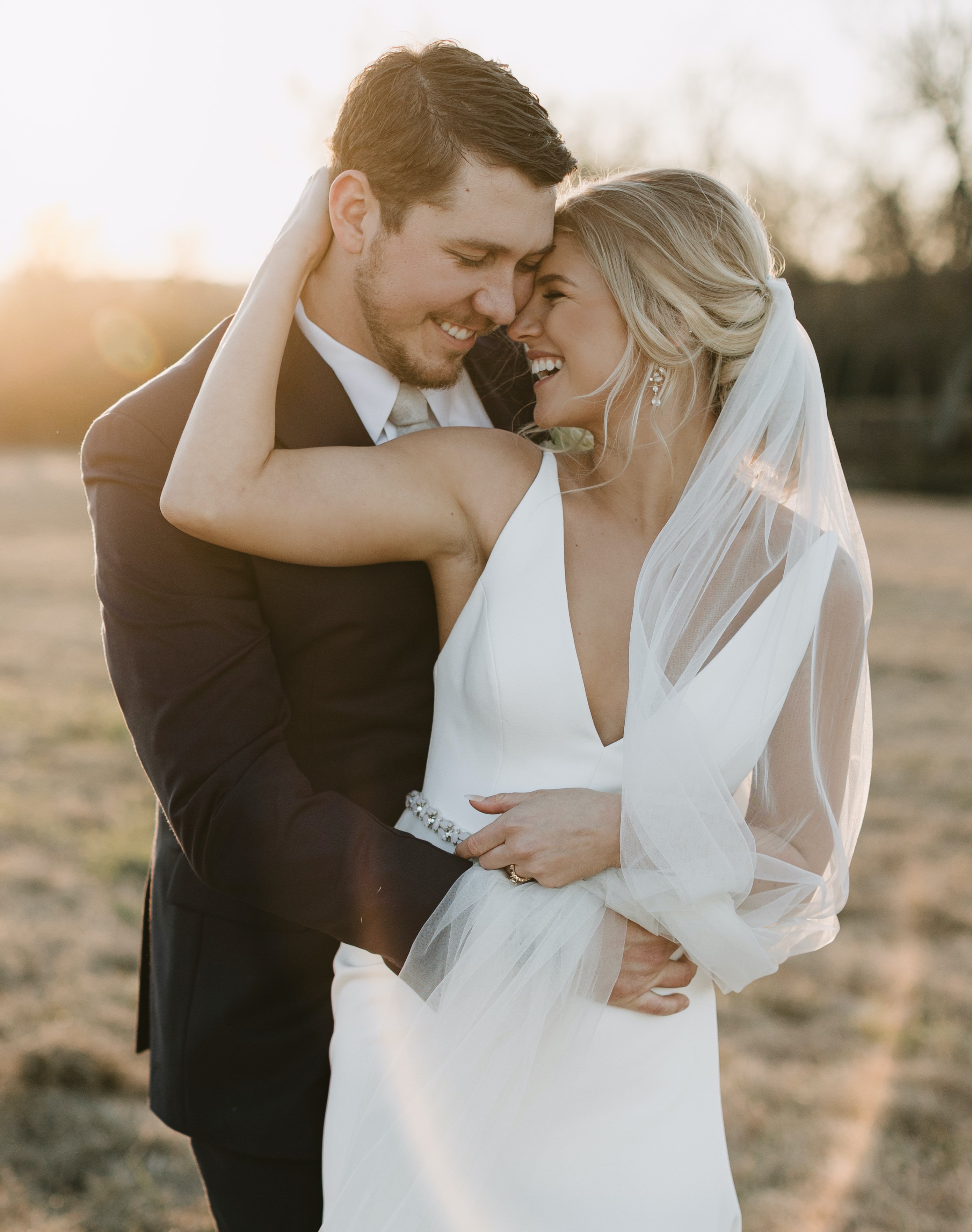 A smiling bride and groom outside at country wedding venue Deep in The Heart Farms in Brenham, TX.