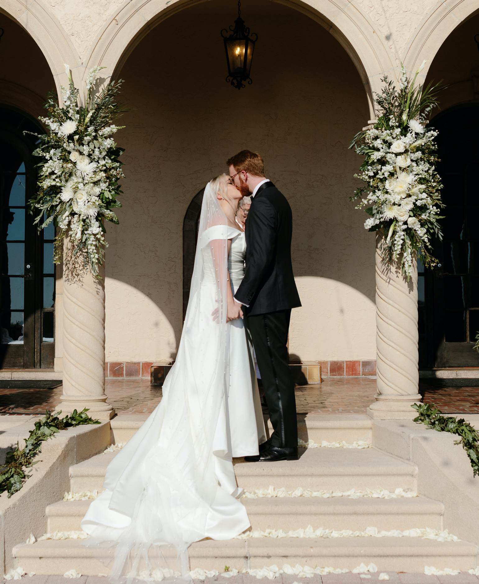 A bride and groom kiss at the altar during their alfresco ceremony in Sarasota, FL.