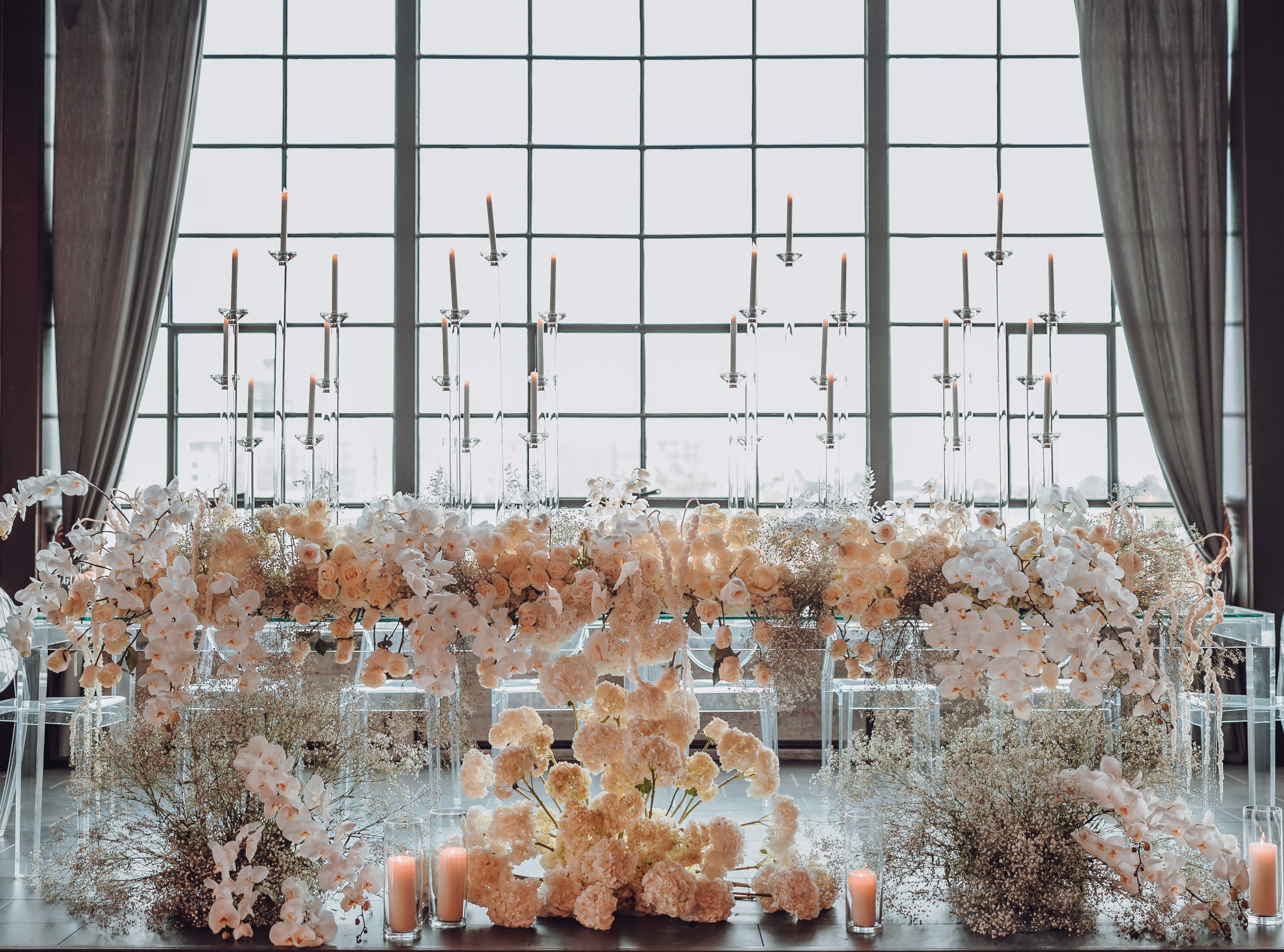 A floral installation full of white flowers and candles for a white, gold and black wedding in Houston, TX.